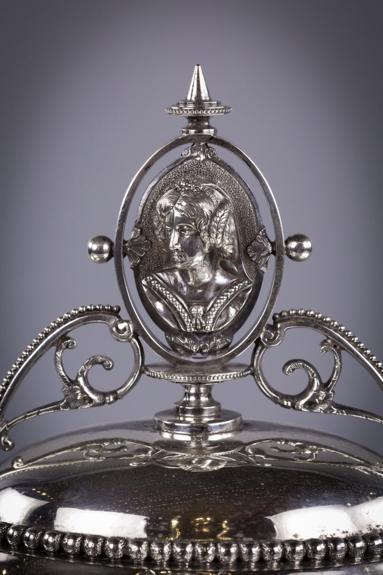 With medallions of classical figures and reindeer handles. Marked: 900/1000, Maker: Wood and Hughes, New York.