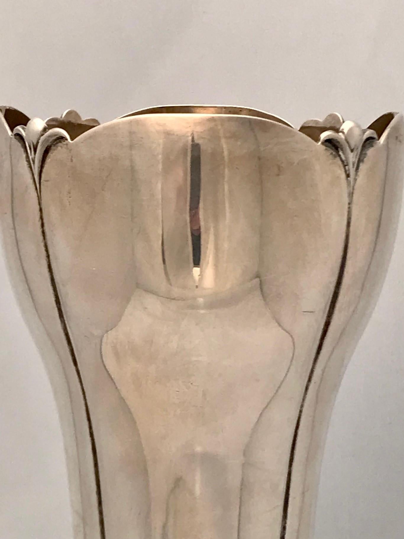 This fine American vase although from the 1930s is in the Art Nouveau taste but the Art Deco period. It compares favorably to the work of Georg Jensen. The Lotus form base is naturalistically modelled and raised on four feet (complete with