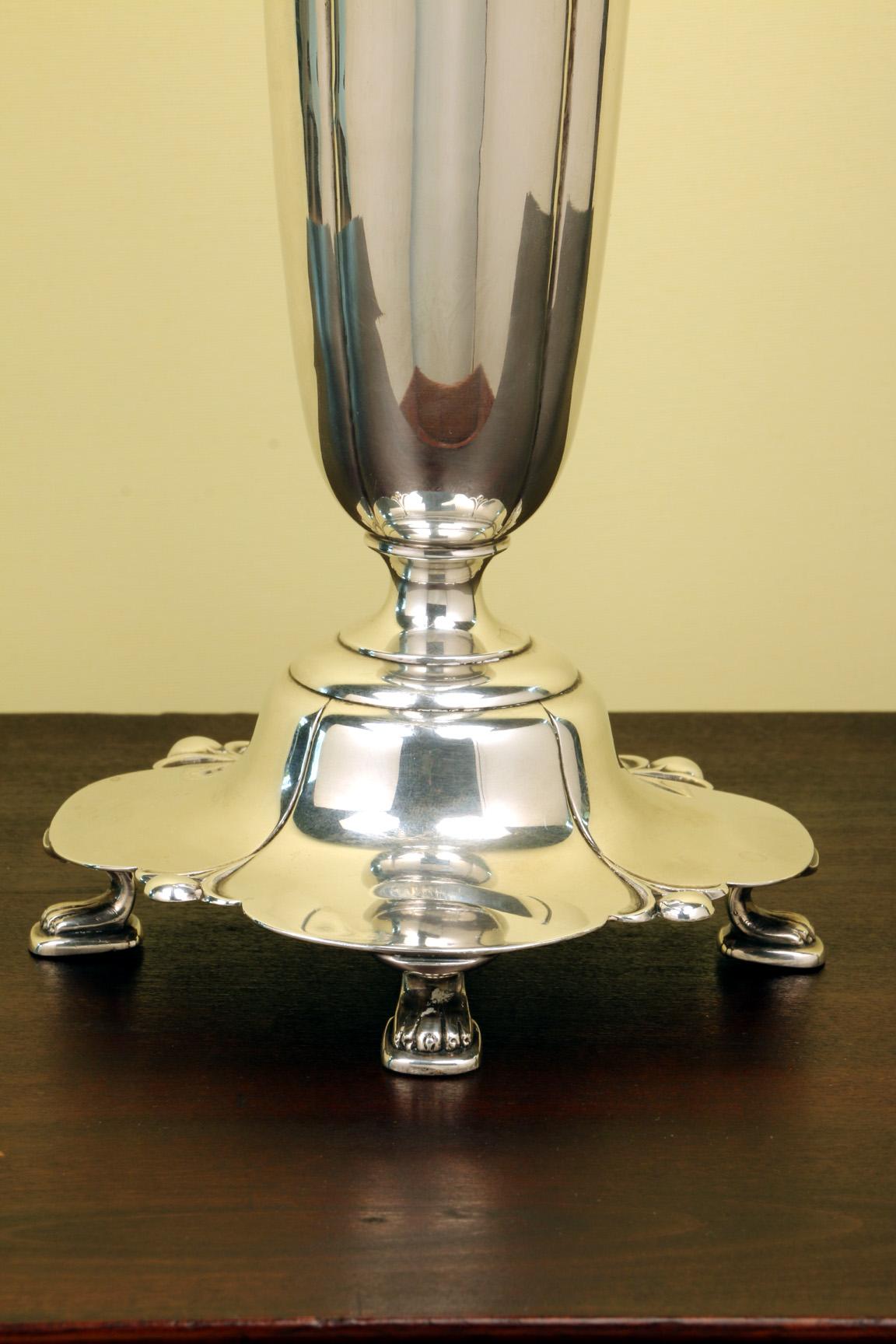 Este fino jarrón estadounidense, aunque es de los años 30, pertenece al gusto Art Nouveau pero al periodo Art Déco. Se compara favorablemente con la obra de Georg Jensen. La base en forma de loto está modelada de forma naturalista y se eleva sobre