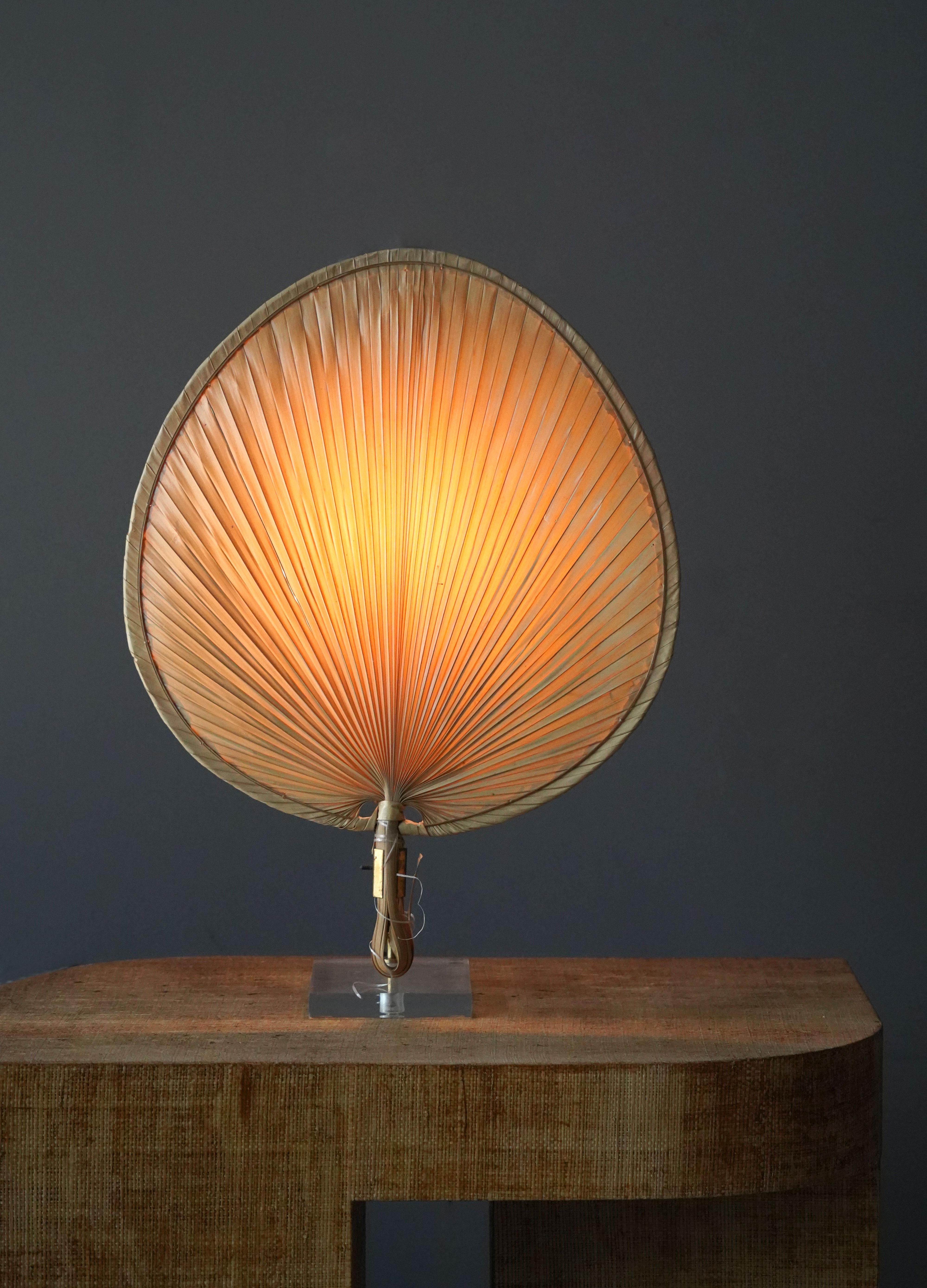 A table lamp in the shape of a Japanese fan, bearing resemblance to Ingo Maurers famous 