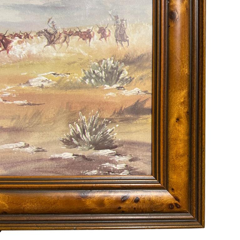 Native American print of cowboys and longhorns on a ranch. Professionally framed in a beautiful burl wood frame, this print features a landscape of wild longhorn bulls during a cattle run. Men with cowboy hats sit upon their horses while roping and