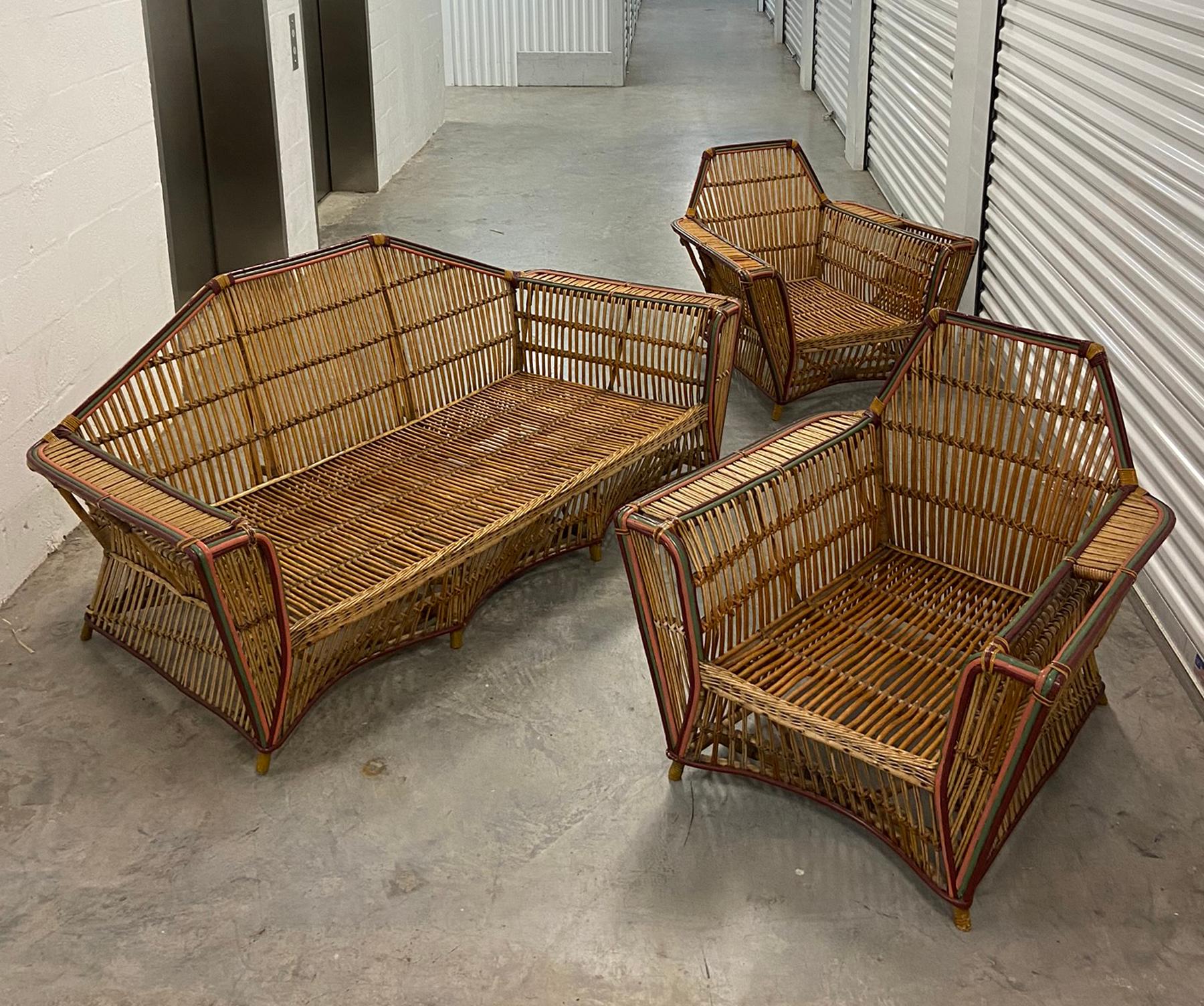 1920s three-piece American split reed stick wicker living room suite. Sofa and two club lounge chairs. Retains original finish with some touch up and minor repairs. Has passable cushions but you probably want to have them re-worked and recovered