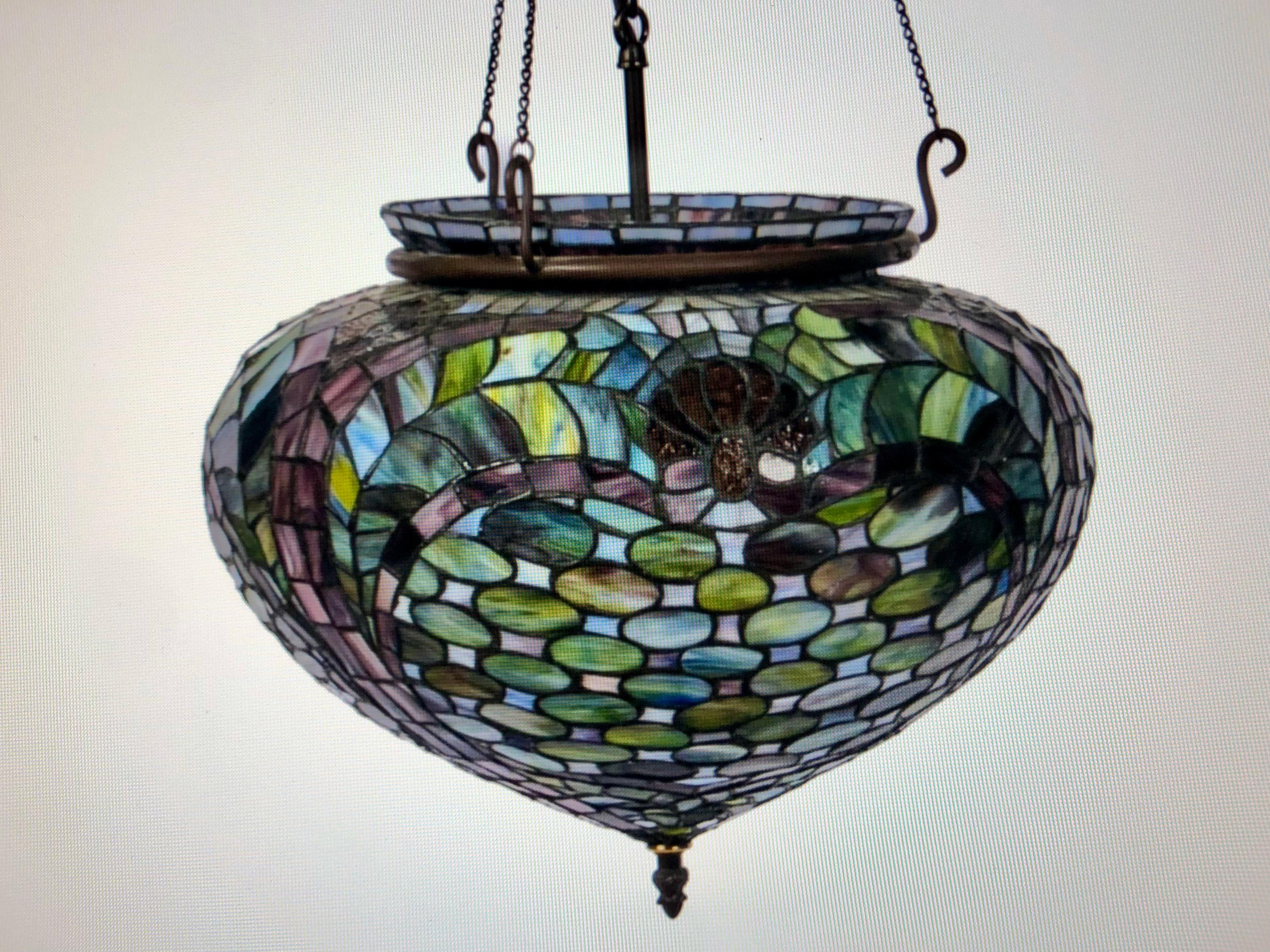 An unusual Tiffany style glass pendant in wonderful condition.
This piece features a large bulbous form and is in a palette of blues, purples and lilacs, with the bulb terminating in a lovely brass finial.
American, 20th century, possibly