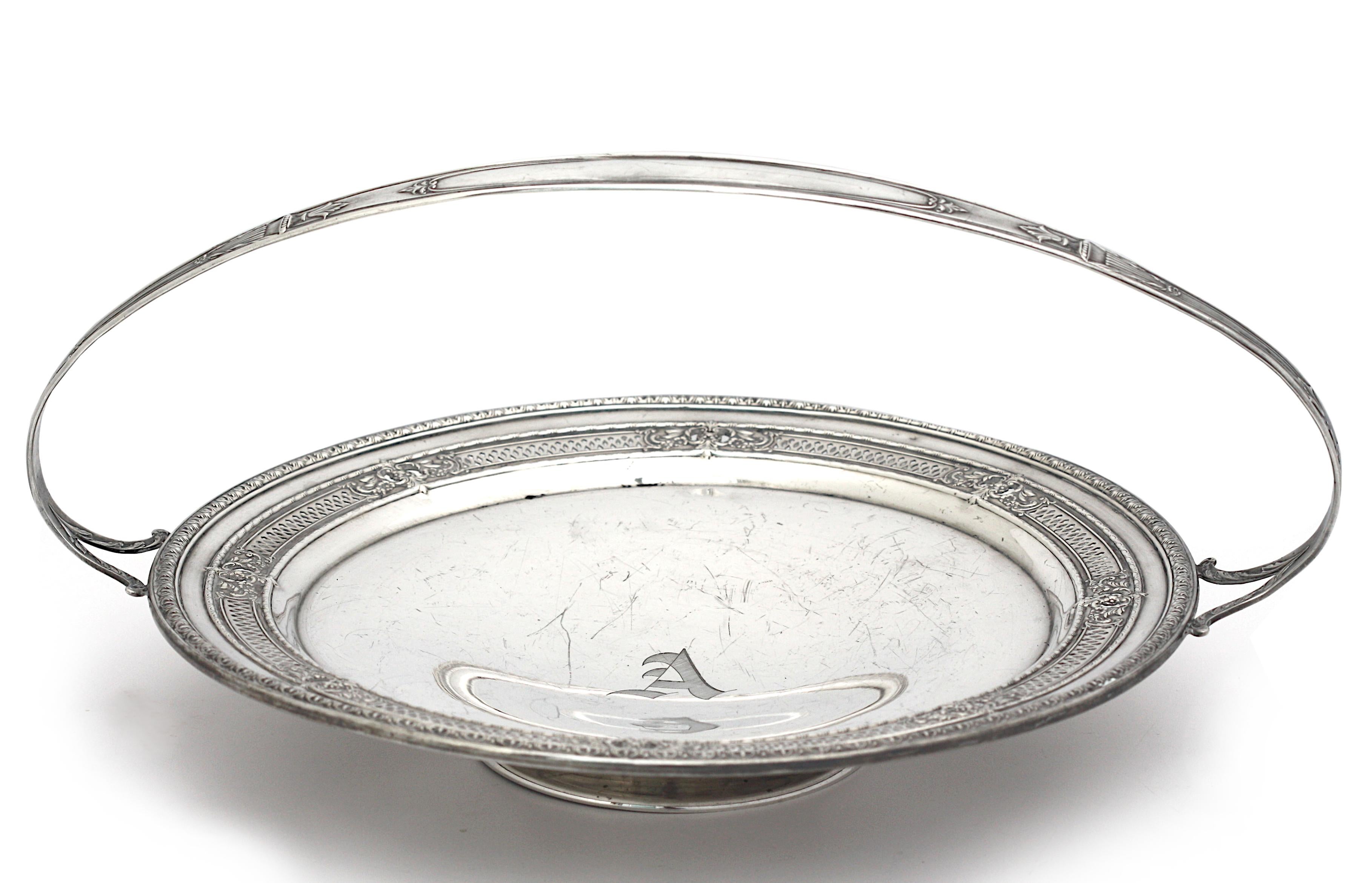 
Cestino da dessert americano con piedini in argento sterling
Marcato International Sterling H15-1A. Il vassoio circolare traforato e cesellato con teste di fiori e volute di foglie, con manico ad anello e piede circolare.
Altezza 6,75 pollici,
