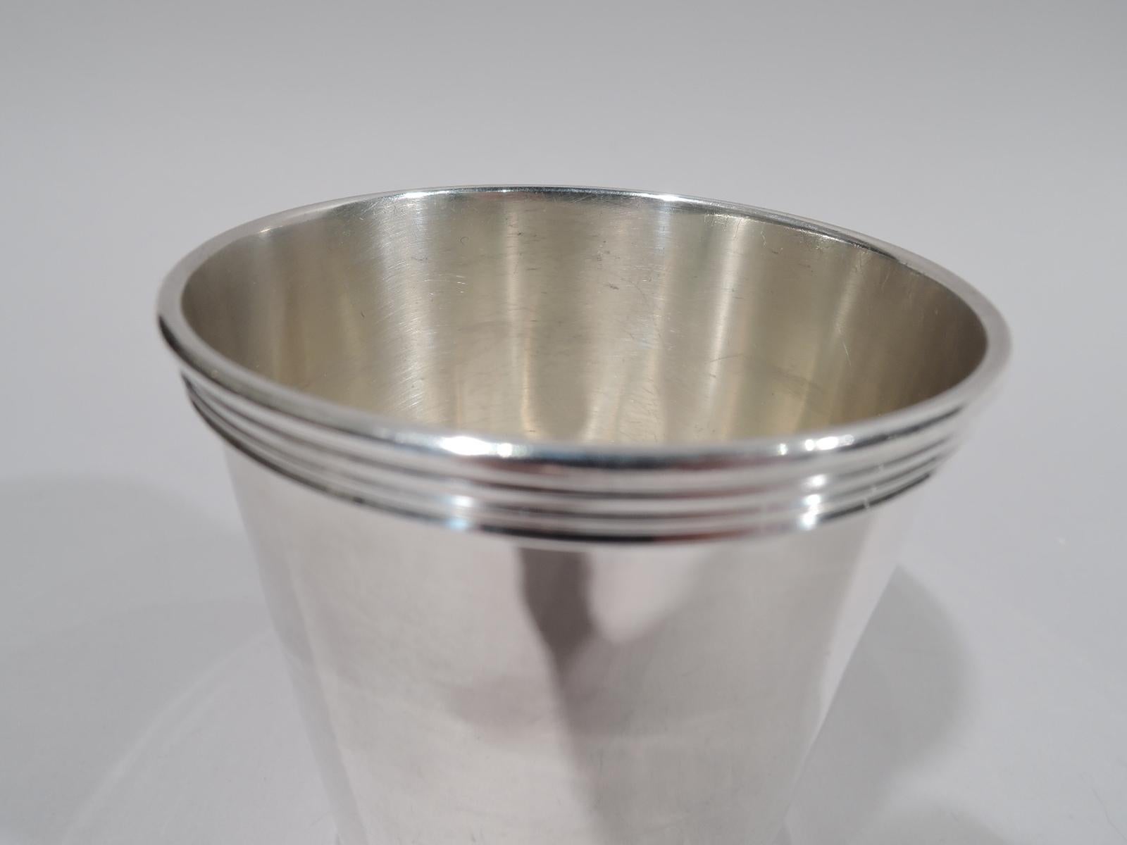 Sterling silver mint julep cup. Straight and tapering sides with reeded rim and foot. A slightly smaller version of the Classic form. Script presentation dated “Christmas 1953” engraved on underside. Marked Trees, a Lexington, Kentucky silversmith