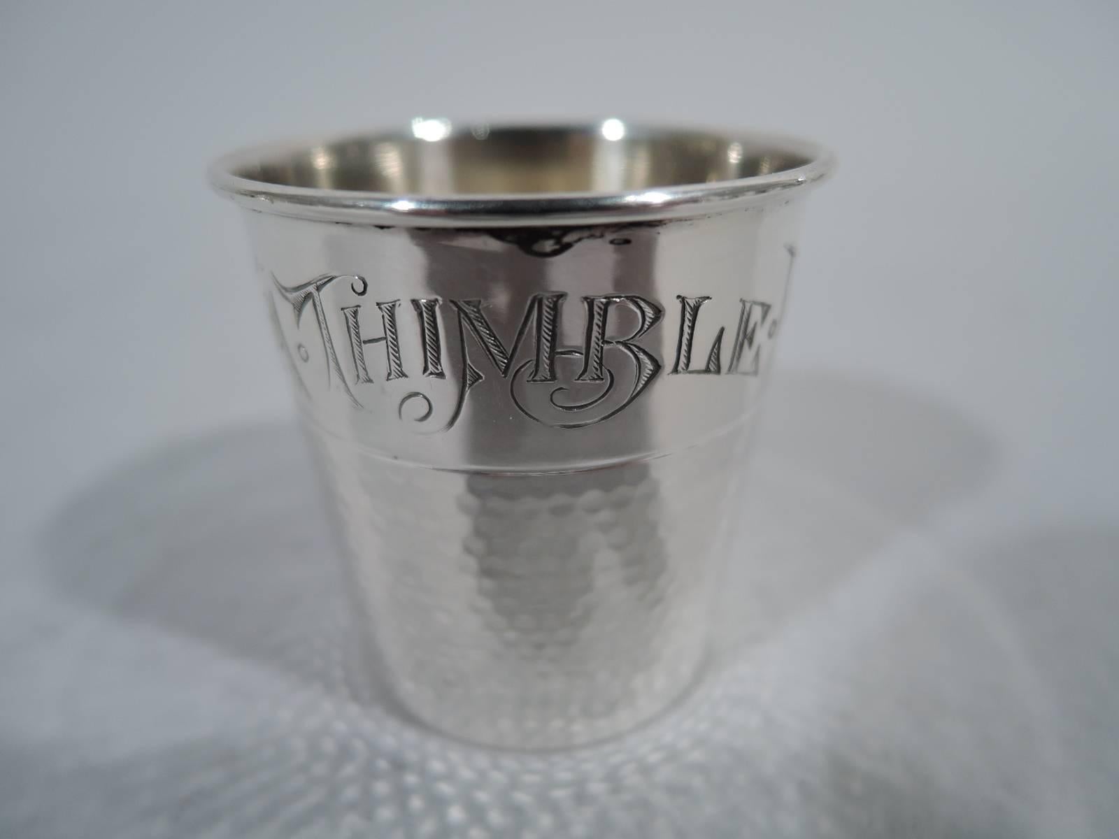 Sterling silver thimble novelty shot glass. Made by Webster in North Attleboro, Mass., circa 1910. Shimmering honeycomb stippling. At top in shaded script is engraved the traditional joke: Only a thimble full. Hallmarked.