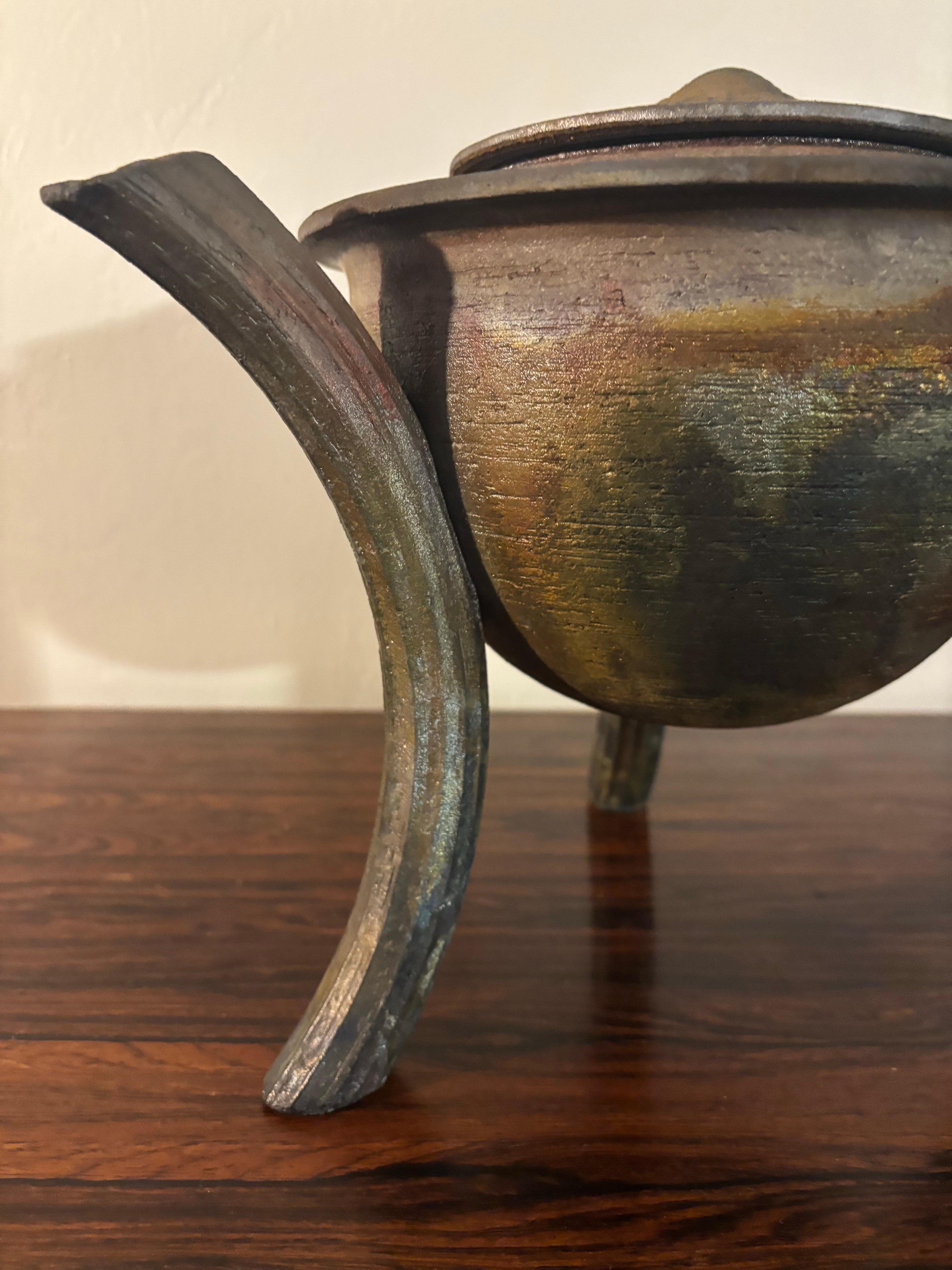 Bellissimo e sapientemente realizzato vaso con coperchio su 3 gambe. 

Studio Pottery americano. Lampo di rame Raku.

Firmato dall'artista sul lato inferiore del coperchio.

Ha un aspetto marrone, ma quando ti avvicini puoi vedere strati di