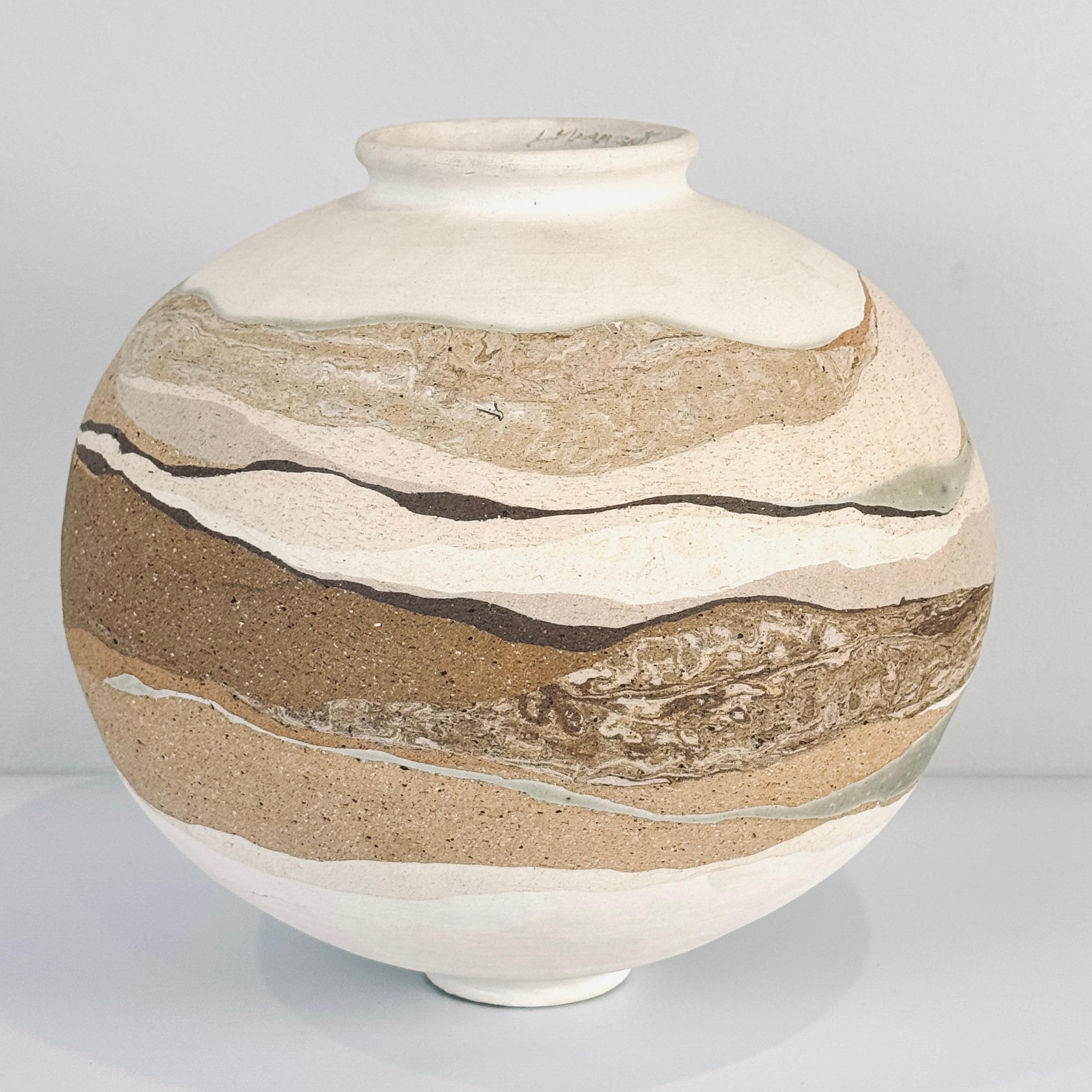 Vaso americano da studio, splendidamente realizzato con strati strutturati nei toni naturali e desertici del crema, del marrone e del blu scisto, firmato in modo indistinto e datato 10-1982 sul bordo interno. Emana calore e la bellezza