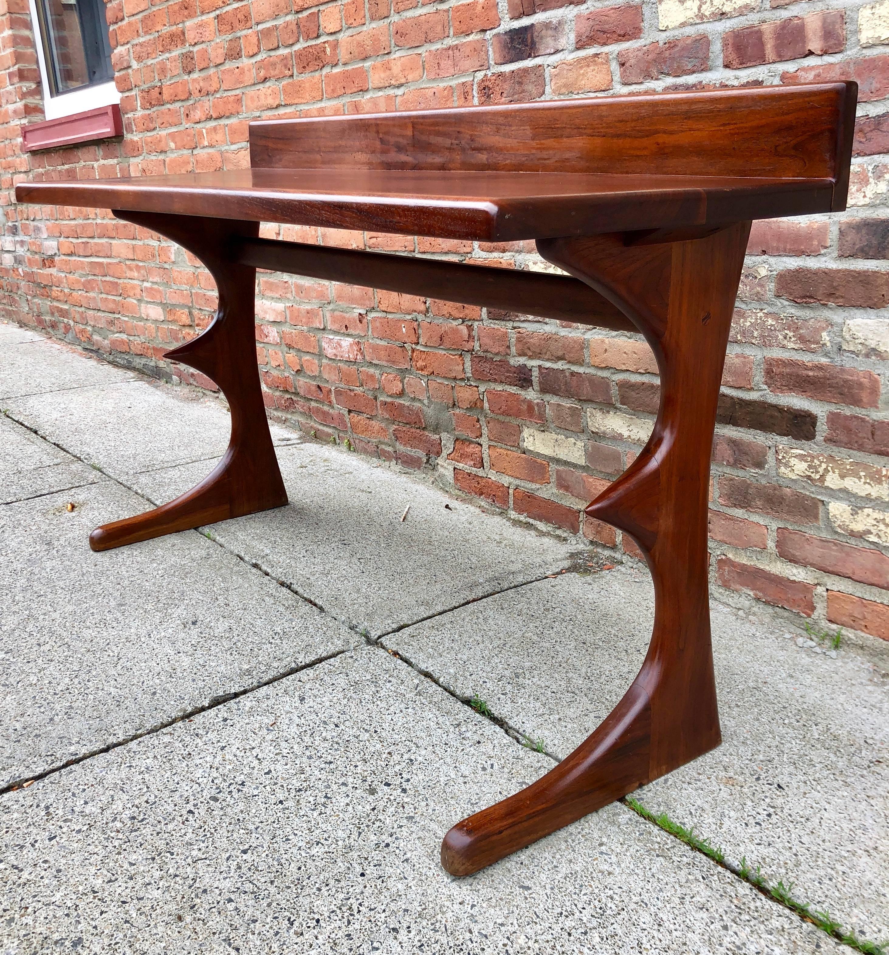 Solid black walnut writing or console table with masterfully carved animal-like sculpted legs, circa 1970. Peg constructed with decorative exposed mortise, the table retains its original linseed oil finish. Tabletop height is 29”. From a Robert