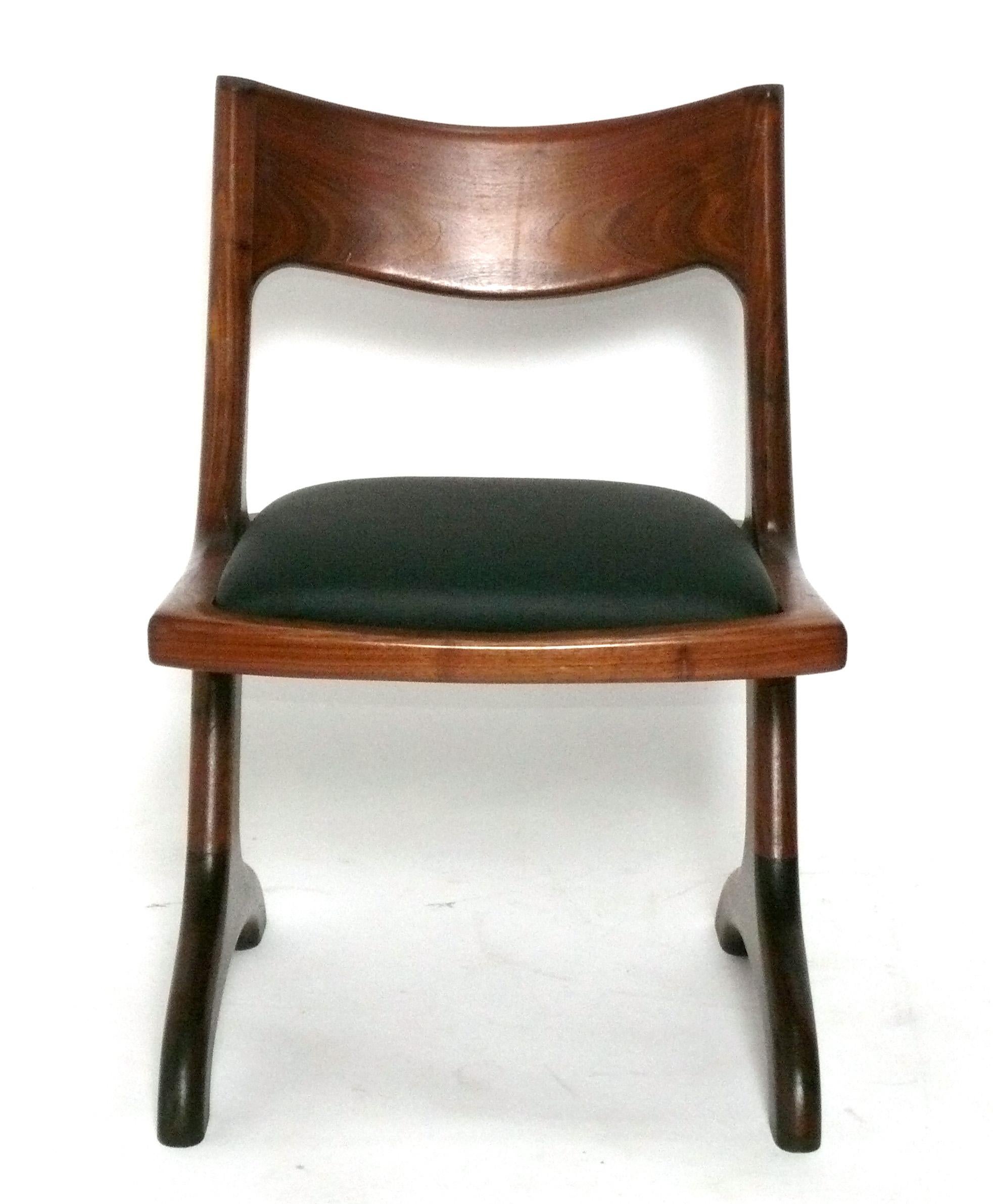 Set di quattro sedie da pranzo scultoree in noce, realizzate a mano da un Craftsman Studio americano, sconosciuto, americano, circa anni '70. Di recente sono state rivestite con un vinile nero a bassa manutenzione simile alla pelle. Questo tavolo ci