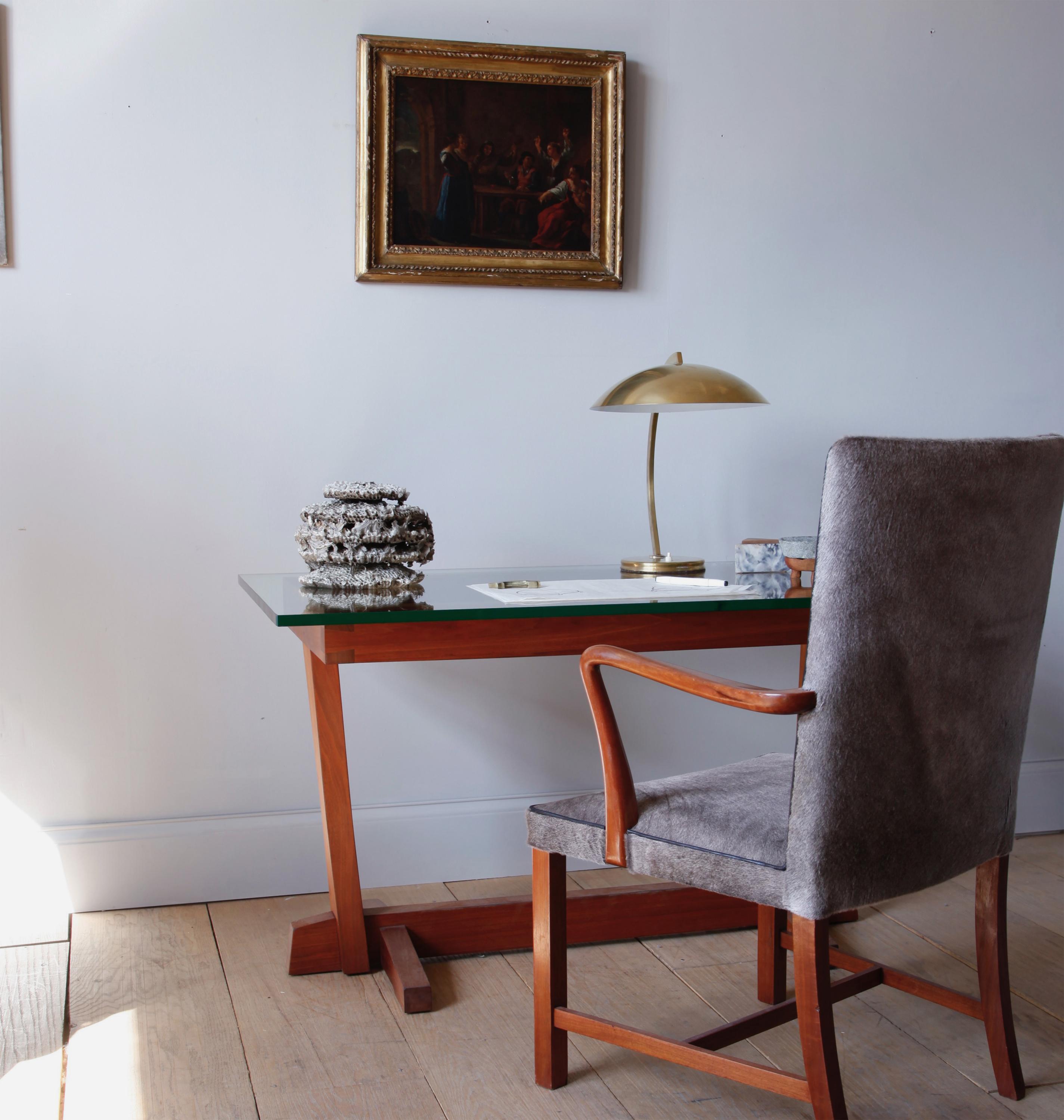 A small writing desk with a thick glass top. The base gorgeously constructed with mortise and tenon joints in the well-known Nakashima conoid design.

 