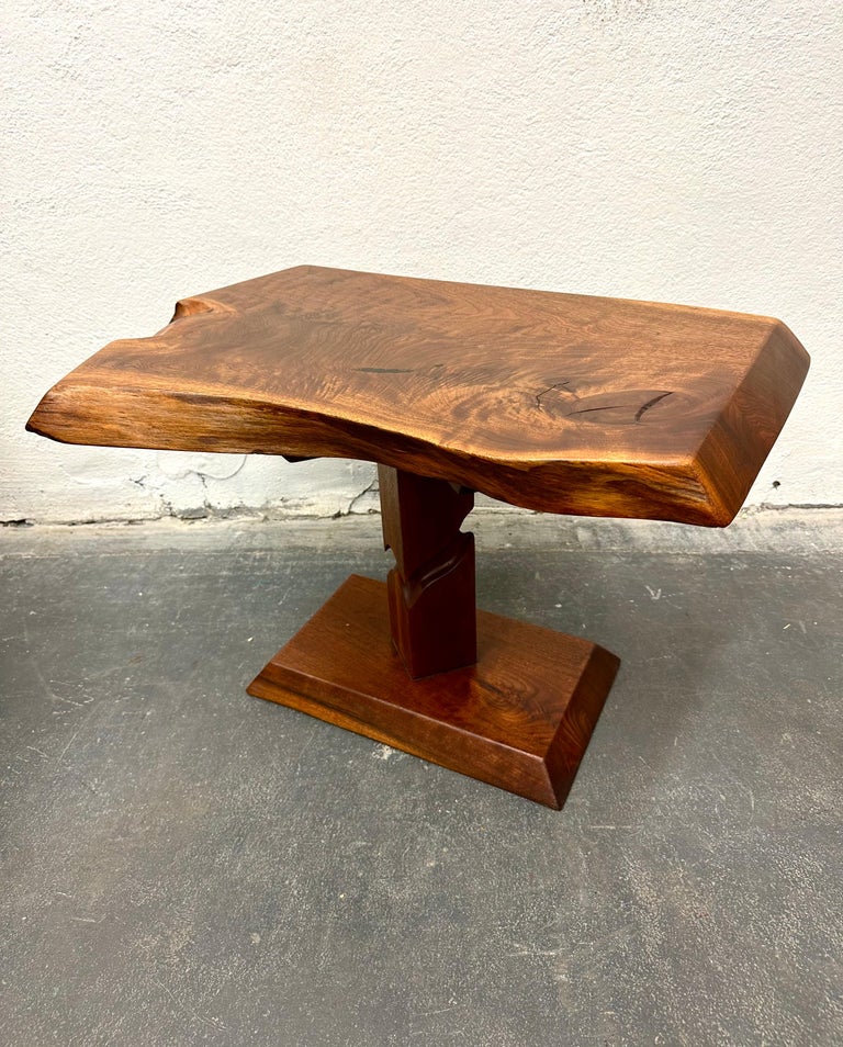 Solid old growth black walnut, the free-edge top raised on notch-carved pedestal base, with a hand-rubbed linseed oil finish. 

Alan Rockwell was part of the Nakashima workshop in the 1960s and 1970s while developing his own unique style in his
