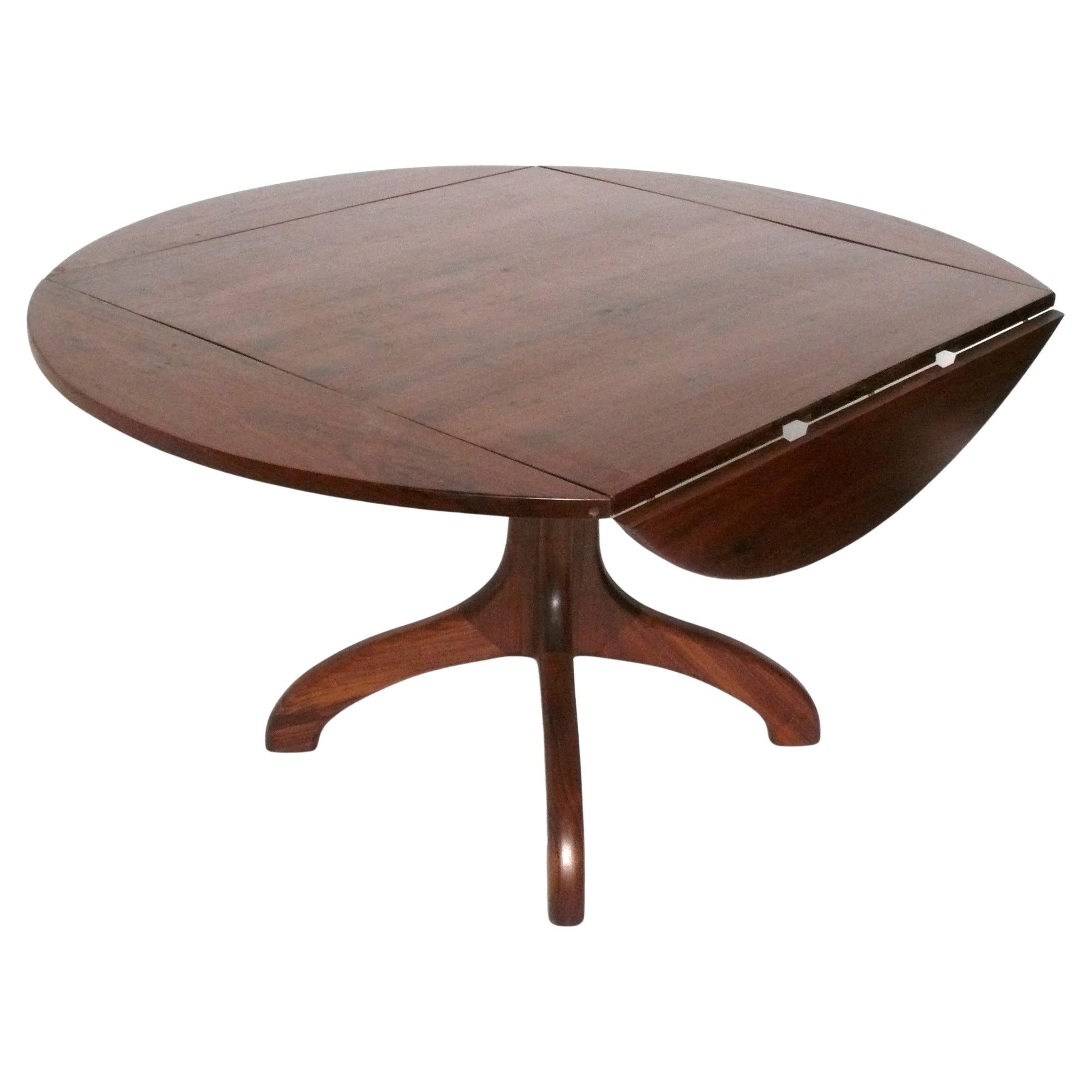 Table de salle à manger sculpturale en noyer de Studio Craft, faite à la main par un Studio Craftsman américain, inconnu, américain, vers les années 1970. D'ingénieuses feuilles repliables lui permettent d'accueillir quatre personnes en table