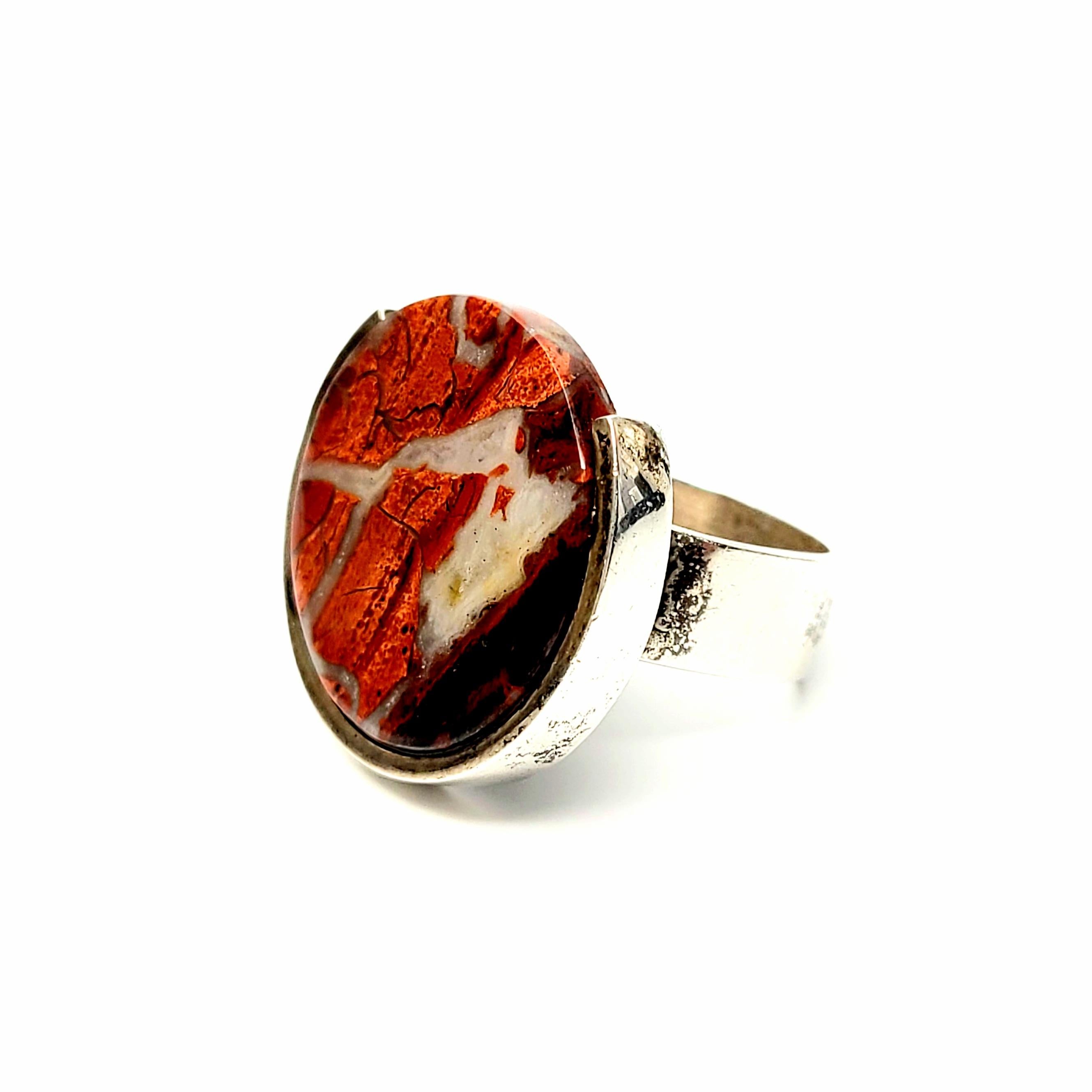 Sterling silver and red jasper modernist ring by American Studio Fingem.

Size 8 1/2

This ring features a large Red Jasper disc with beautiful veining. The band shape is a rounded corner square.

Measurements: 3/4