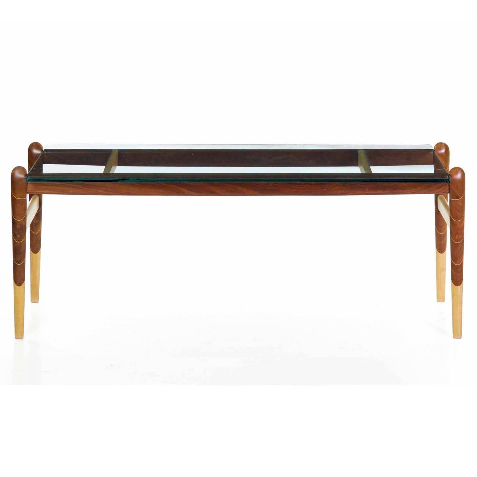 This is such a distinct and interesting coffee table that is relatively simple at a first glance, inordinately complex upon closer examination. The legs formed from maple and walnut, these glued together before carving and sculpting the legs by hand