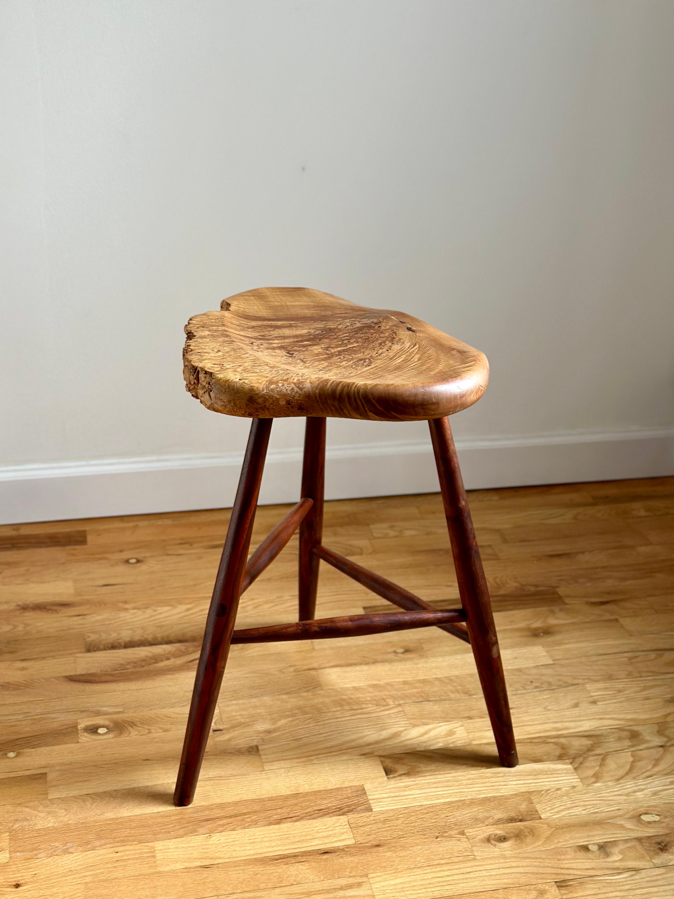 A counter-height stool executed in American black walnut and with a sculptural, free edge seat in maple burl by Oregon-based craftsman, Michael Elkan. Walnut has a warm, reddish hue and beautiful figure, providing striking contrast against the seat.