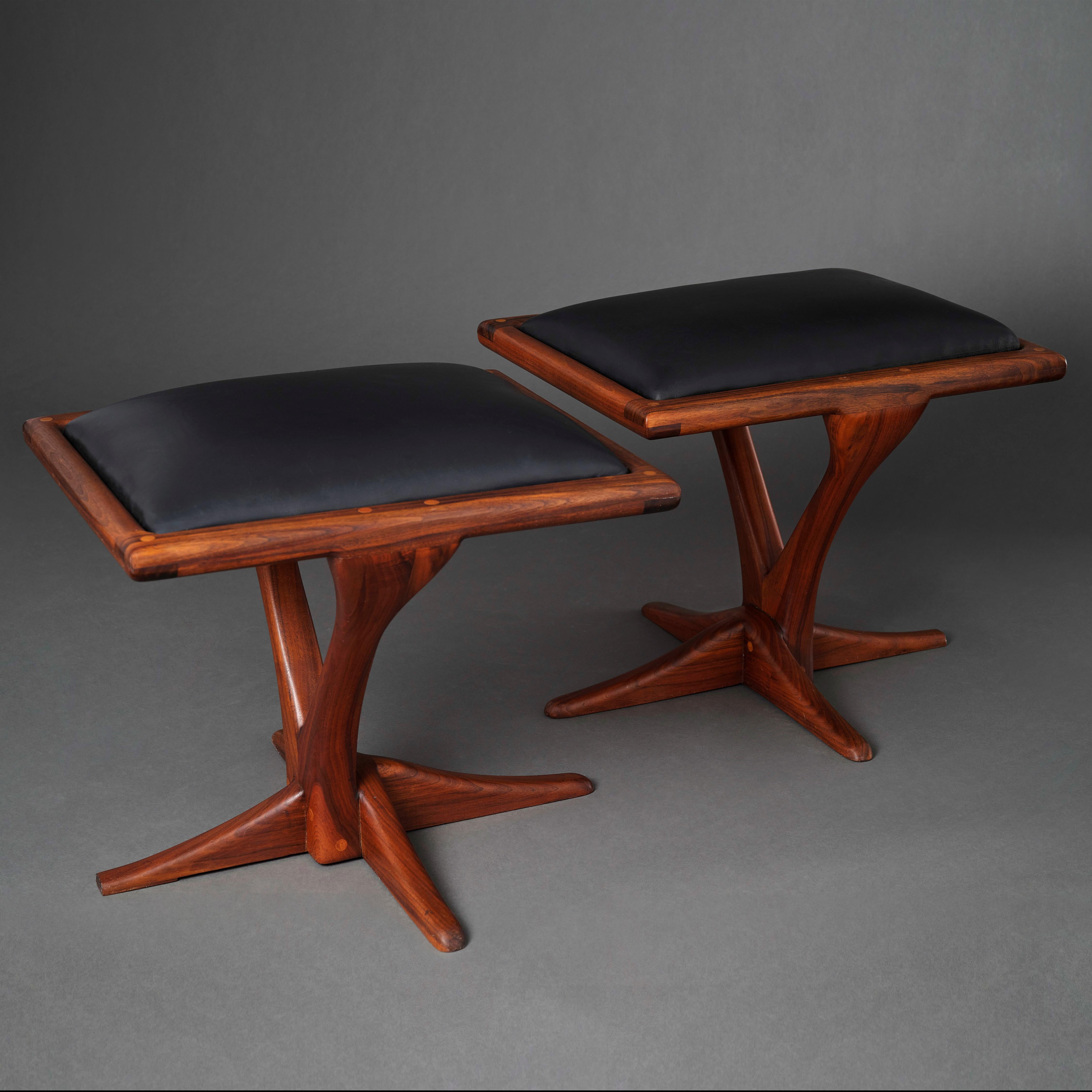 Un escultural par de reposapiés Studio Craft americanos en nogal con cojines de piel, obra del ebanista afincado en San Francisco Michael Bock. Un pie de cada ejemplo está escuadrado para que puedan unirse uno al lado del otro y presentarse como un