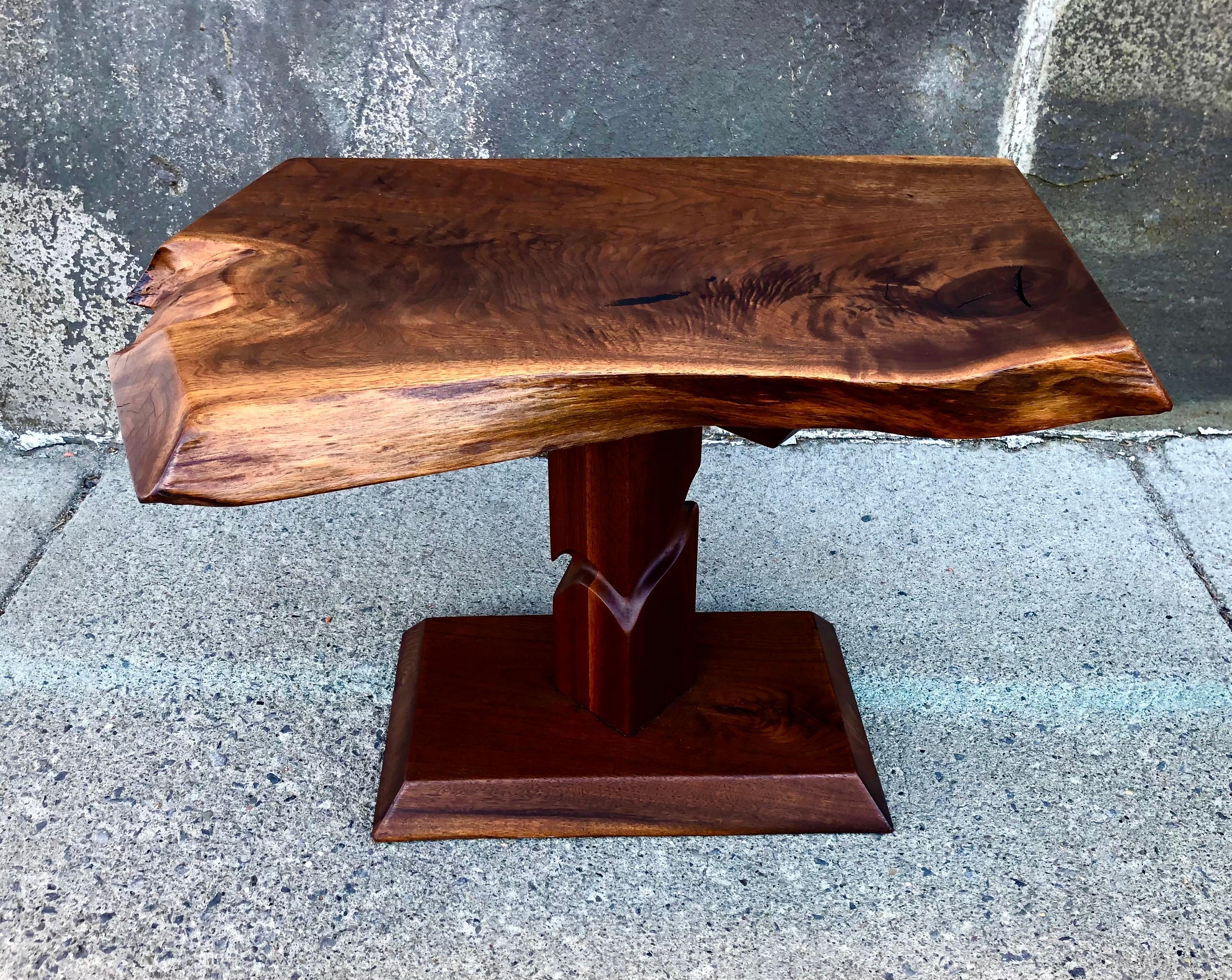 Solid old growth black walnut, the free-edge top raised on notch-carved pedestal base, with a hand-rubbed linseed oil finish. Alan Rockwell was part of the Nakashima workshop in the 1960s and 1970s while developing his own unique style in his