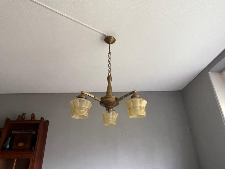 Striking little 1920s Art Deco chandelier with 3 golden-yellow shades.

If you are looking for a remarkable light fixture to grace your living space then this American Art Deco Style chandelier of practical proportions could be gracing your home