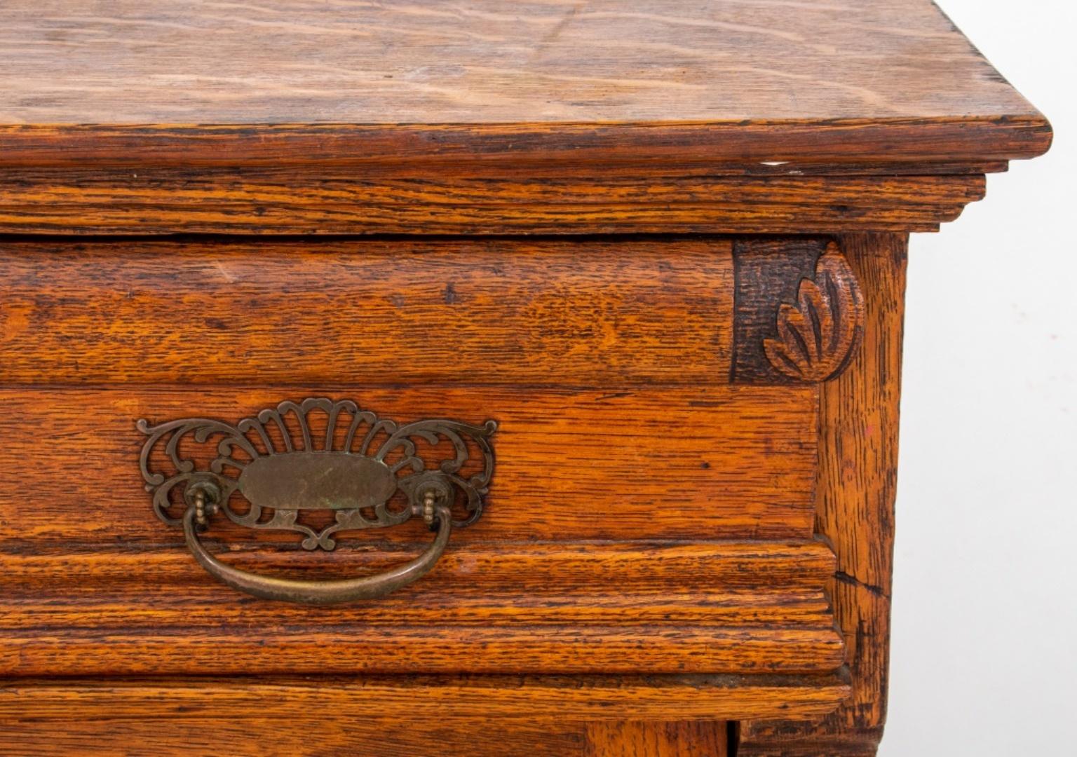 American carved tiger oak chest of drawers or dresser, having five drawers and one door, brass hardware, circa 1900. Measures: 45.5