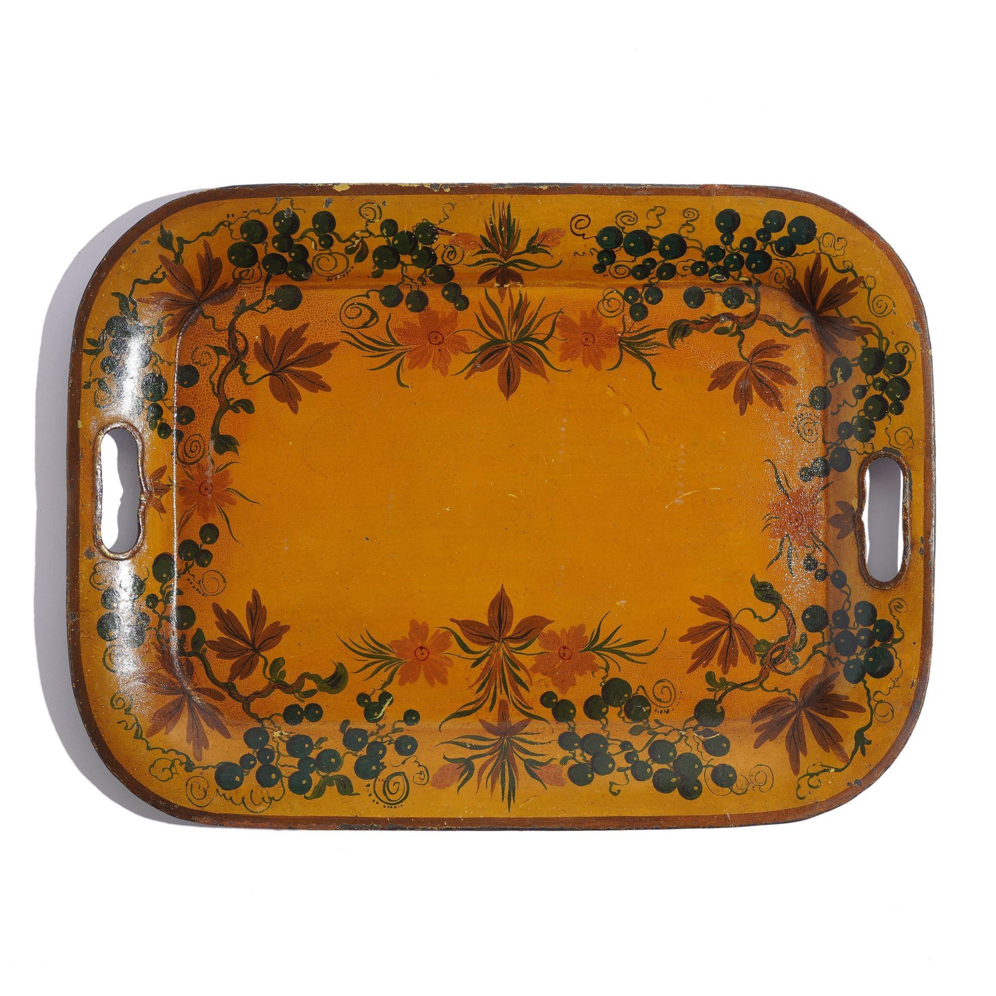 Tole tea tray with rolled rim pierced with handle grips. The tray has been hand painted with trailing flowers and foliage on a yellow ground. Original surface.

American, late 1800’s.
