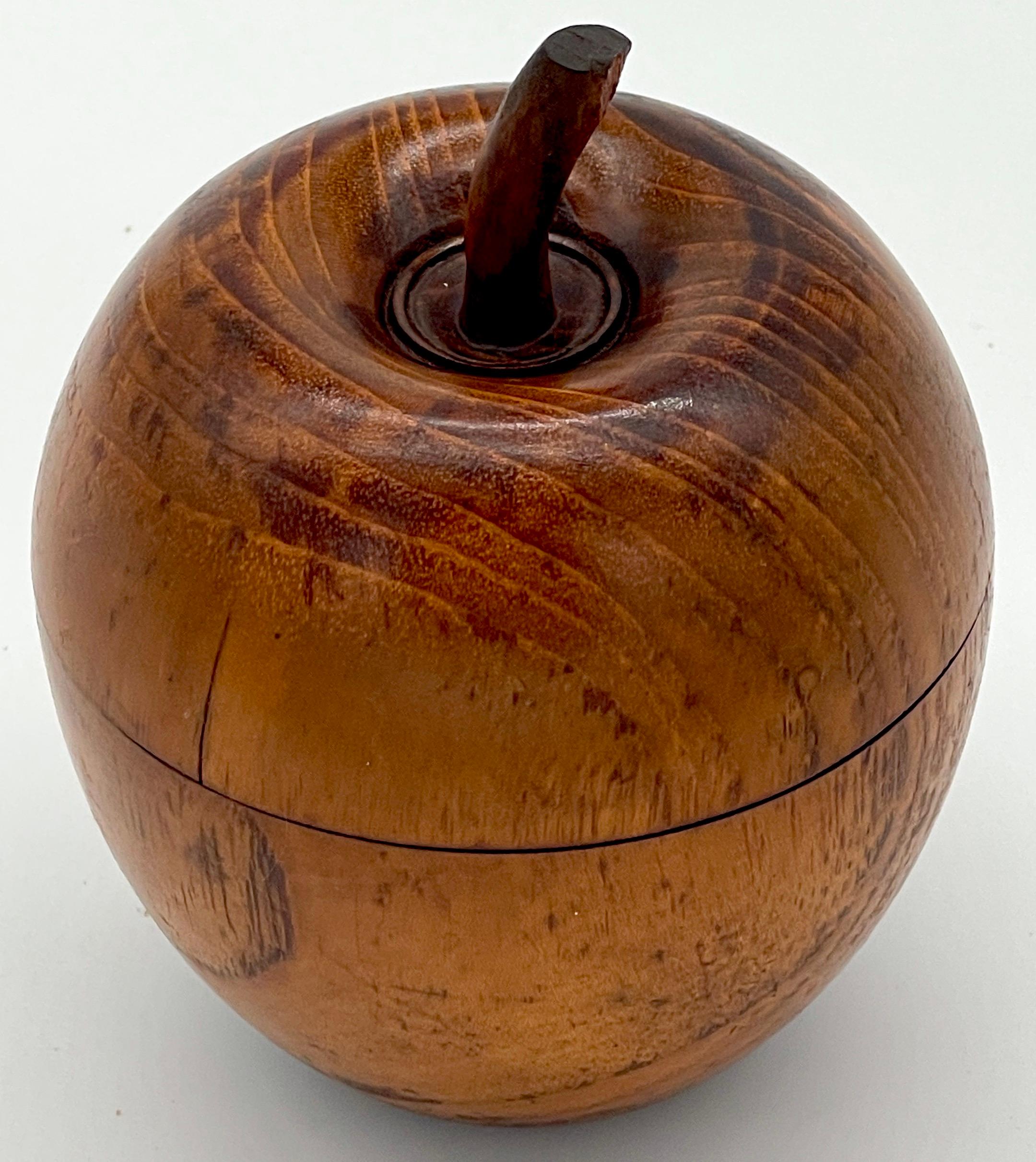 American Treen Apple Motif Tea Caddy, 1900s

American Treen apple motif tea caddy dating circa early 20th Century, a delightful testament to the artistry of its time. Meticulously carved from wood, this charming piece comes in two parts, with a lift