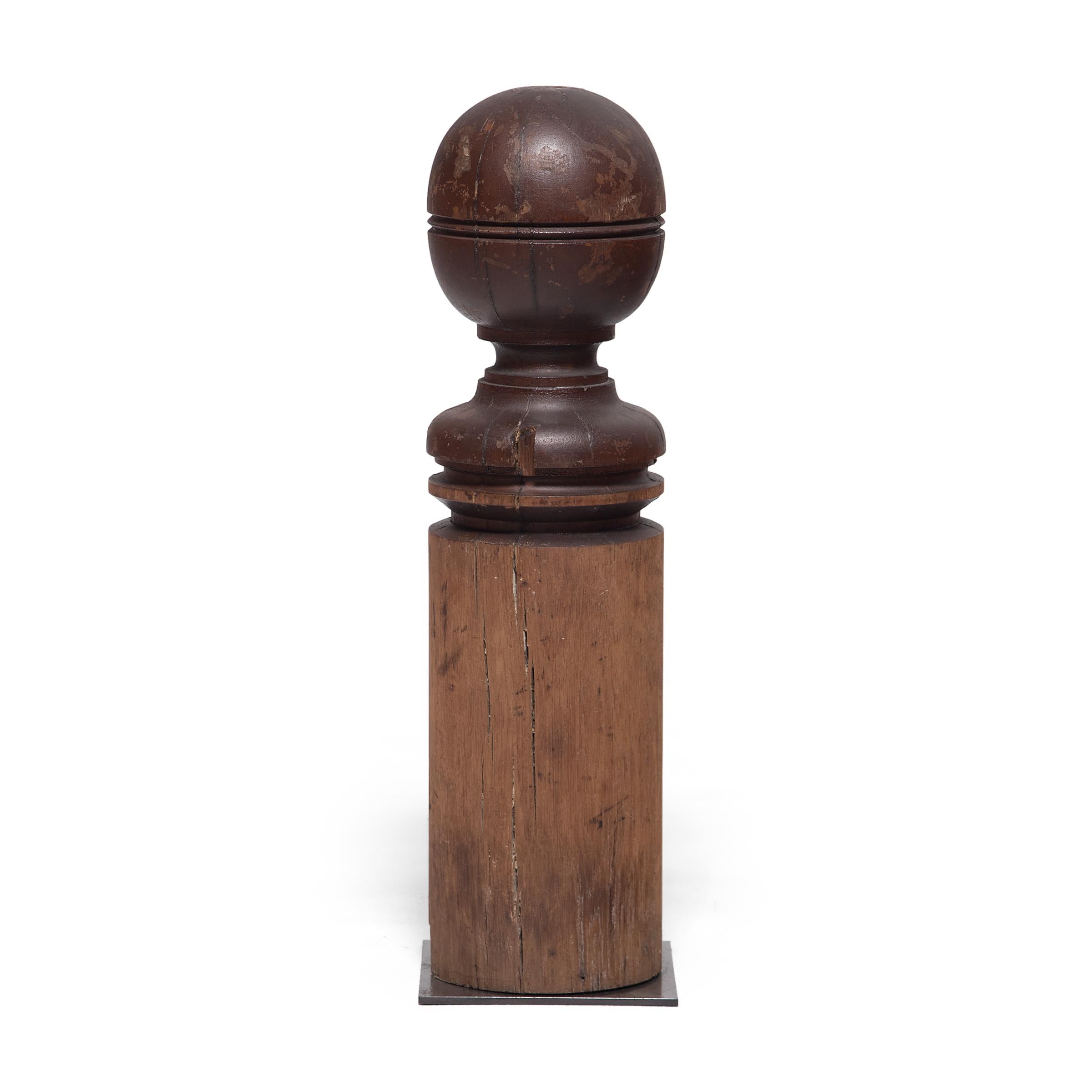 Dated to the early 20th century, this antique turned newel post was crafted from American oak with a simple ball finial top. The original dark finish has faded along the round post to reveal the natural texture of the oak with a subtle gradient. Set
