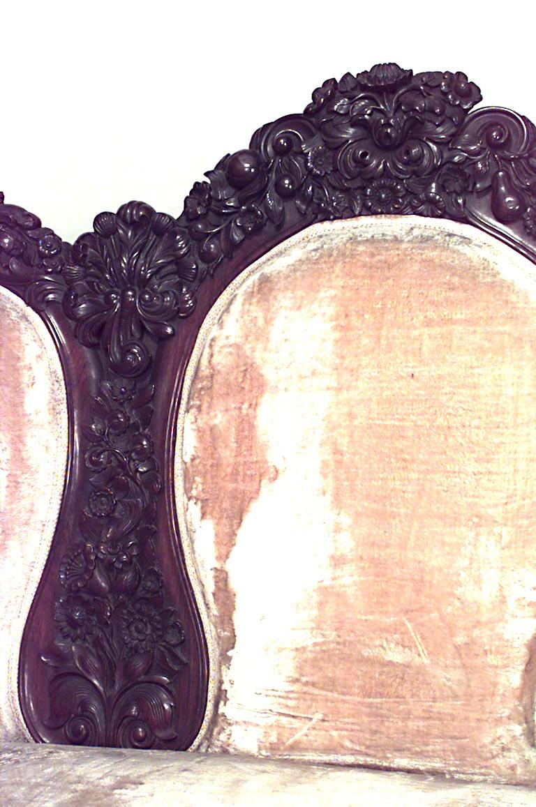 Canapé victorien américain en bois de rose à triple dossier ovale sculpté et tapissé de beige.
