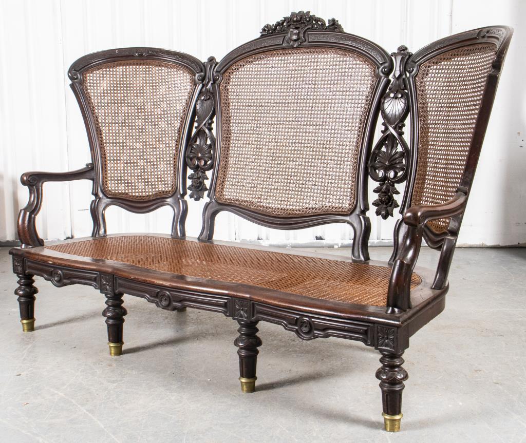 American Victorian settee in carved wood with caned seat and back. Measures: 44