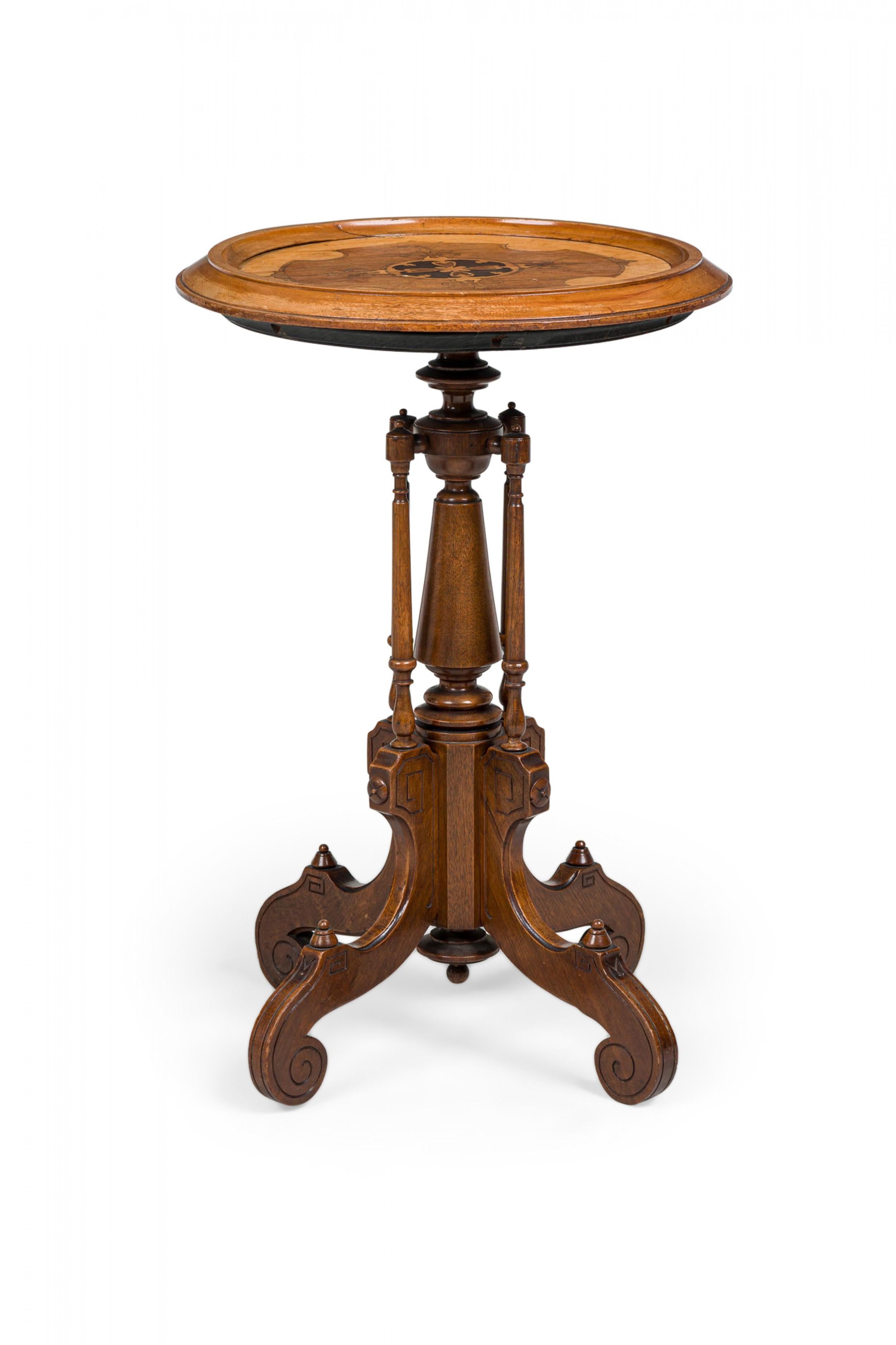 American Victorian carved wood plant stand / side table with a molded top featuring a central inlaid parquetry medallion with contrasting grain, standing on a turned stem with 4 perpendicular supports and flattened scroll feet with incised borders.