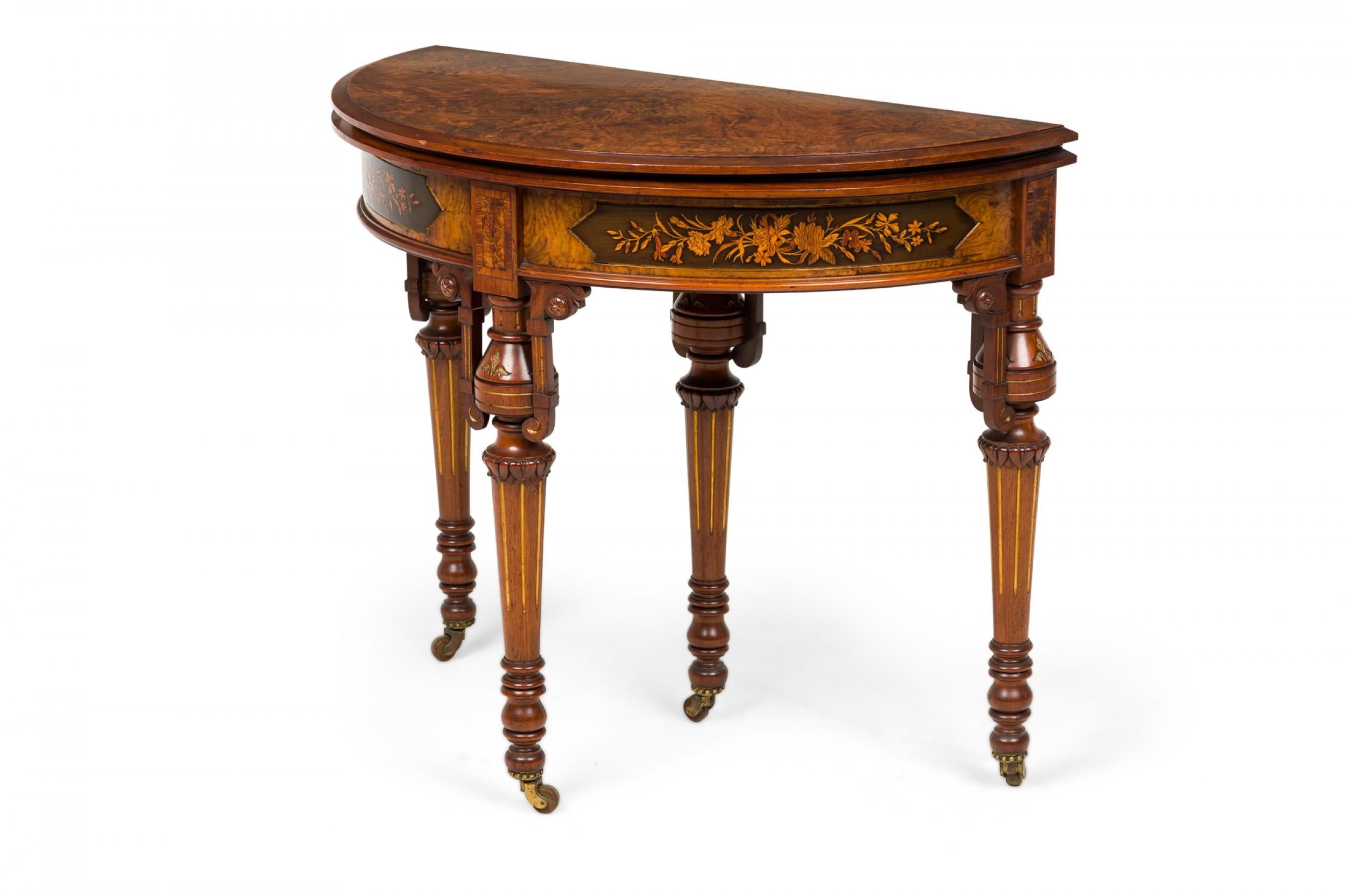 American Victorian demilune wooden console table with floral inlaid apron with gold detailing and a burl wood hinged top that unfolds with an extendable back leg to create a circular surface finished with green embossed leather, resting on 4 turned