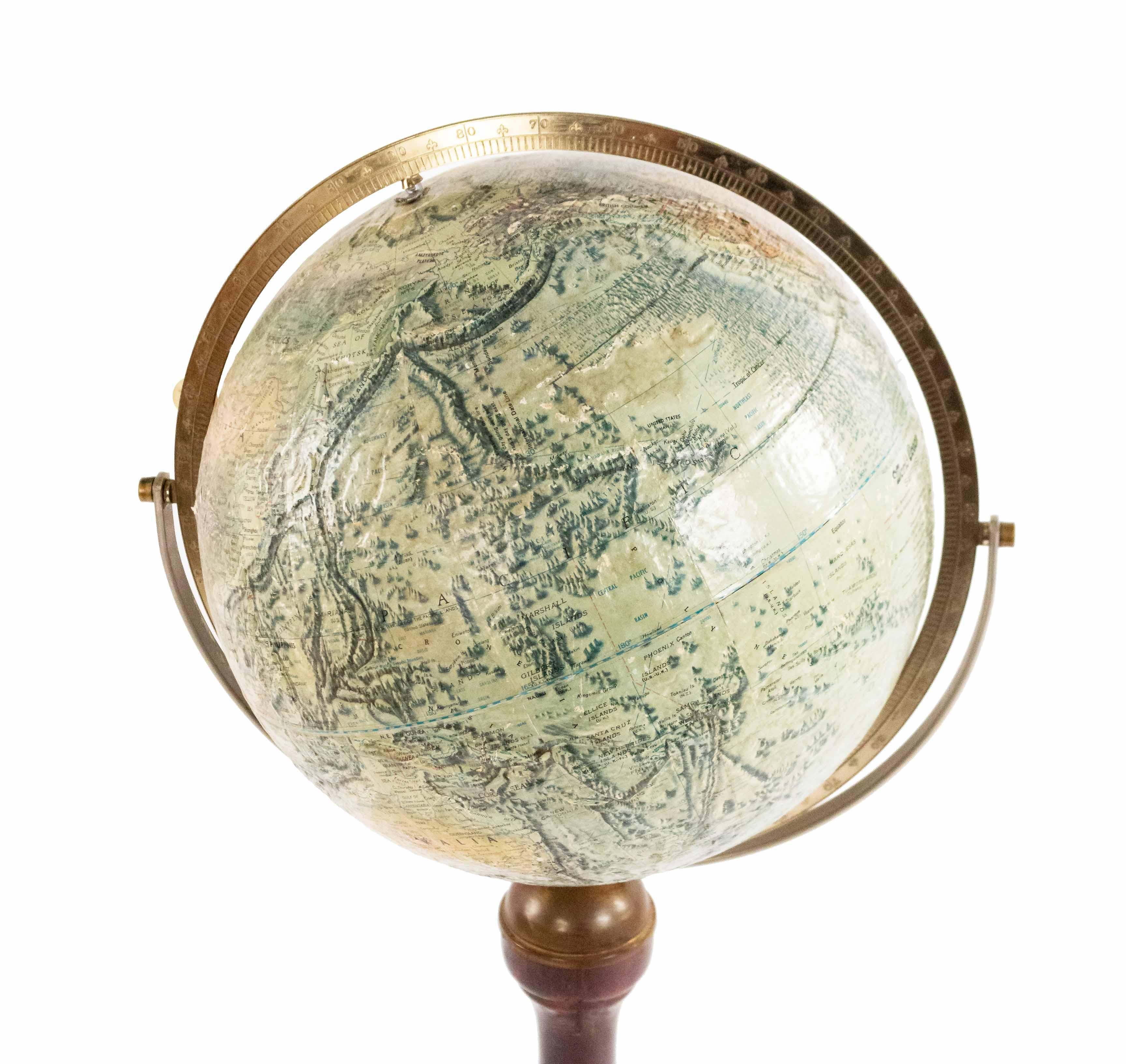 American Victorian style globe of the world with a relief supported on a pedestal base stand with 3 legs.
  