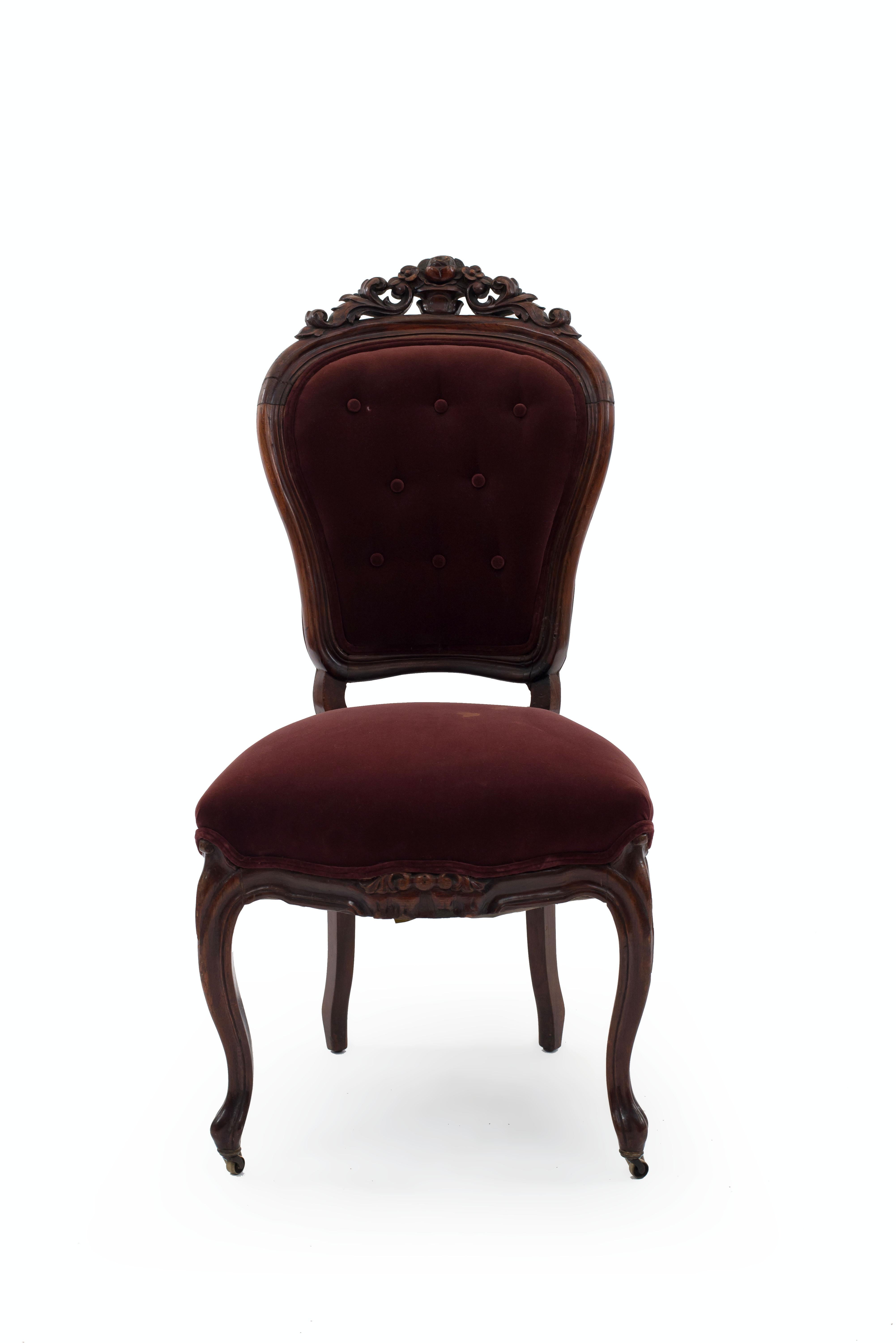 Pair of American Victorian rosewood side chairs with filigree carved crest and button tufted red velvet upholstery.