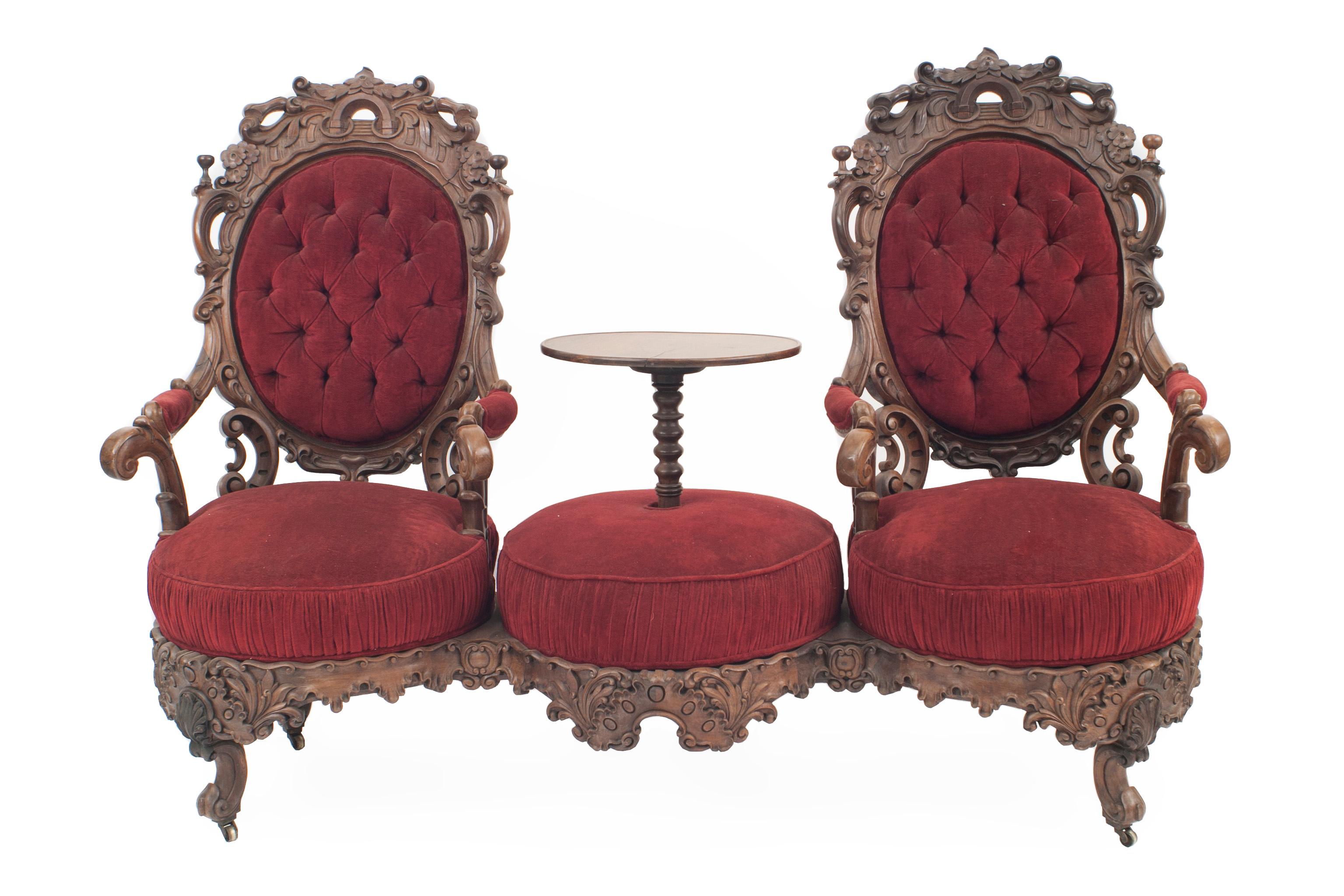 American Victorian rosewood carved double swivel seat tete a tete with table center and red velvet upholstery

