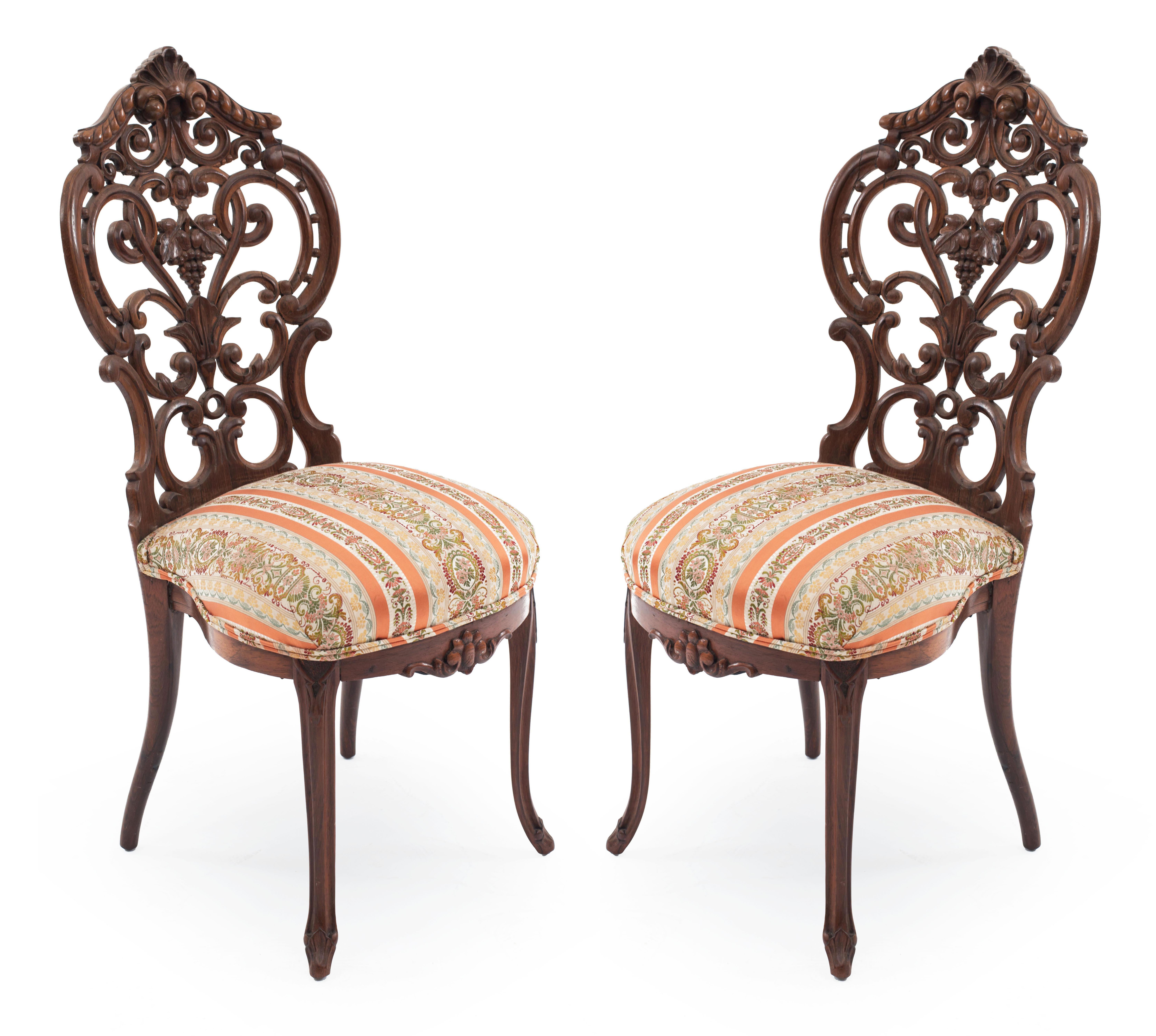 Pair of American Victorian rosewood side chairs with carved filigree and scroll design back and shell crest. (Attributed to John Henry Belter).