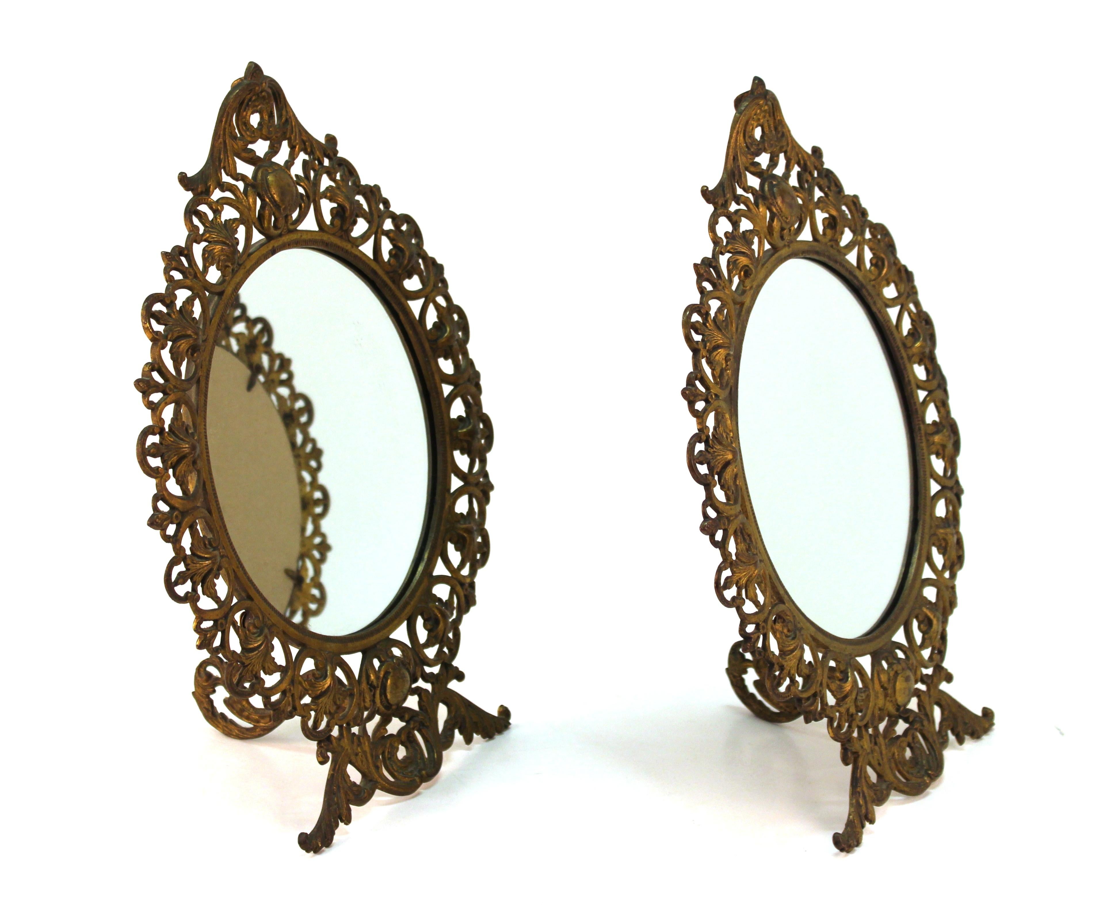 Pair of American Victorian round table mirrors set in elaborate gilt metal frames. The pair dates from the 1890s and is in excellent vintage condition.