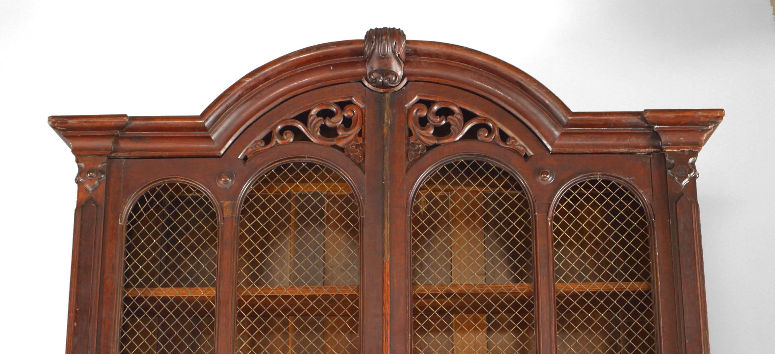 American Victorian (2nd Quarter 19th Century) plum-pudding mahogany secretaire-bookcase with arched pediment above grilled doors and a maple veneered fitted fall-front drawer
