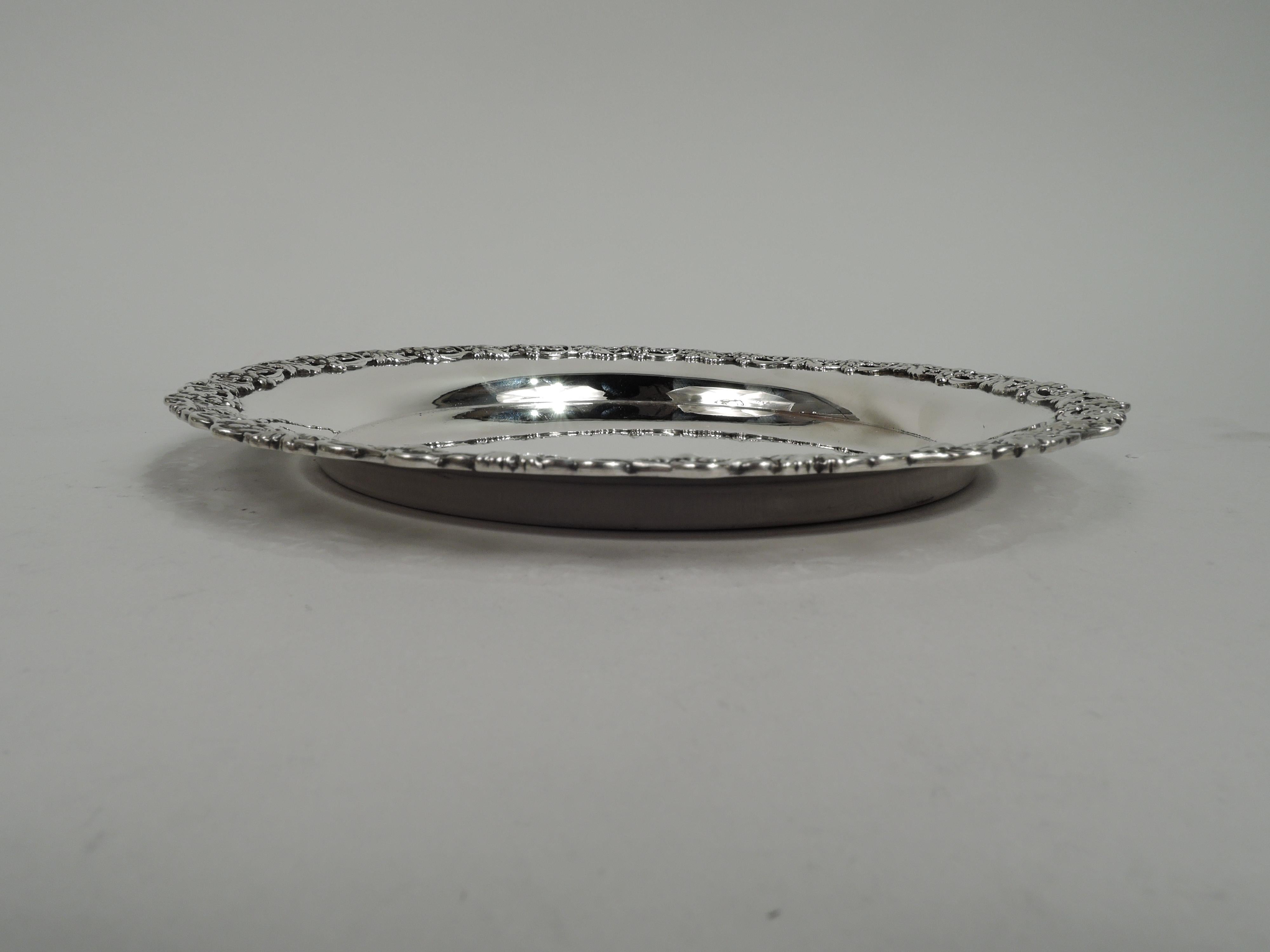 Victorian sterling silver wine bottle coaster. Made by Dominick & Haff in New York in 1895. Round with applied and open fruiting grapevine rim. Fully marked including dated maker’s stamp and no. 250. Weight: 6.3 troy ounces.  