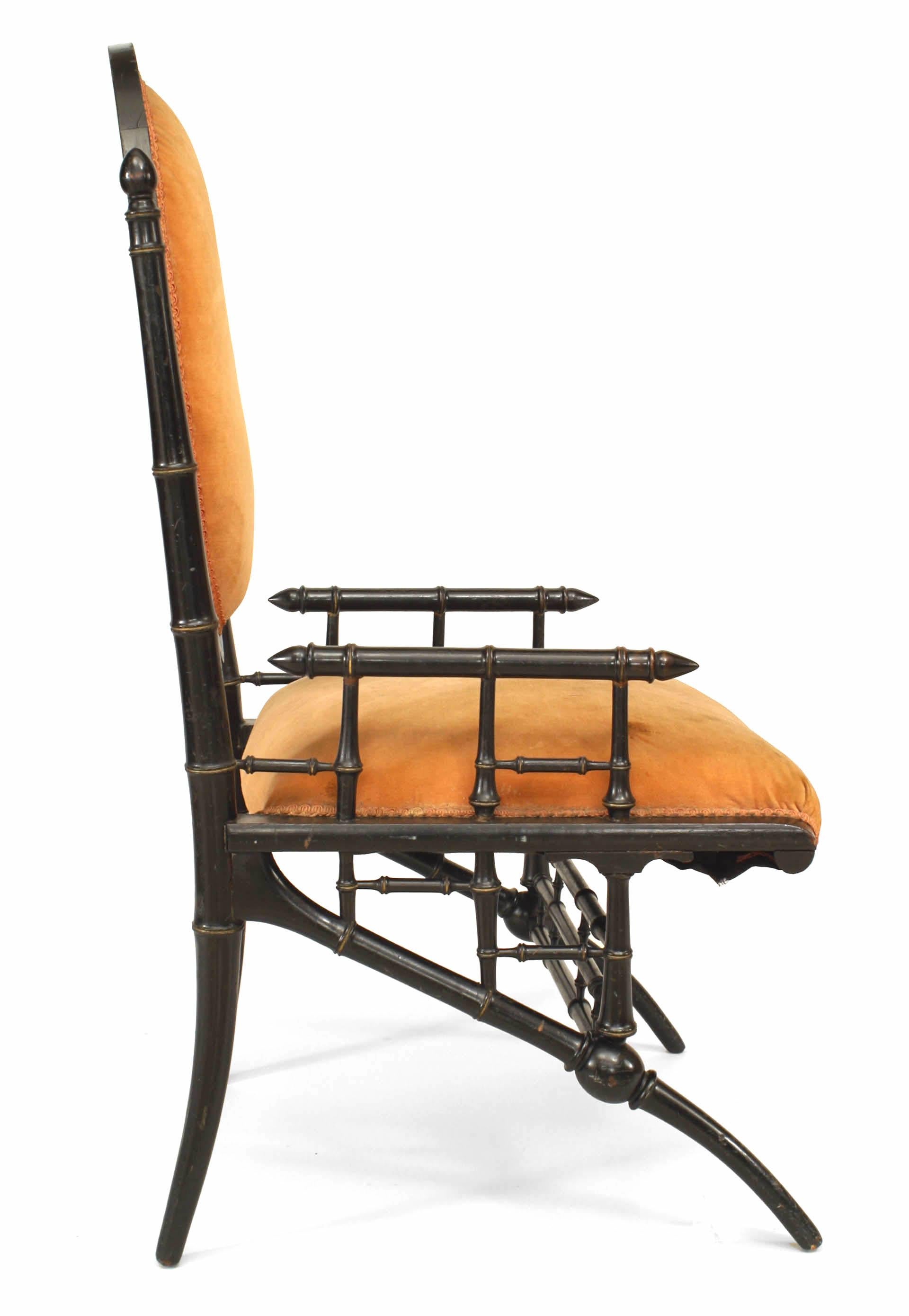American Victorian ebonized and gilt trimmed arm chair with faux bamboo design and peach velvet upholstery.
      