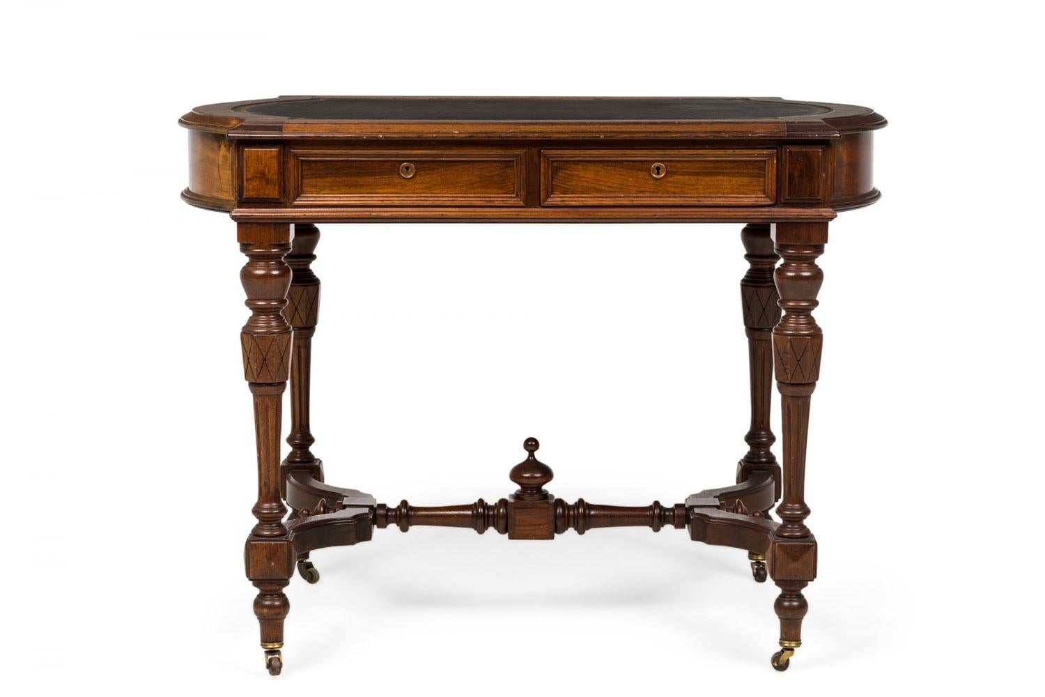 Scrivania vittoriana in noce di forma rettangolare sagomata con scrivania in pelle nera con bordo in rilievo dorato, 2 cassetti estraibili, bordi modanati, traversa tornita a forma di H con terminale centrale e gambe tornite su rotelle.

Perdite