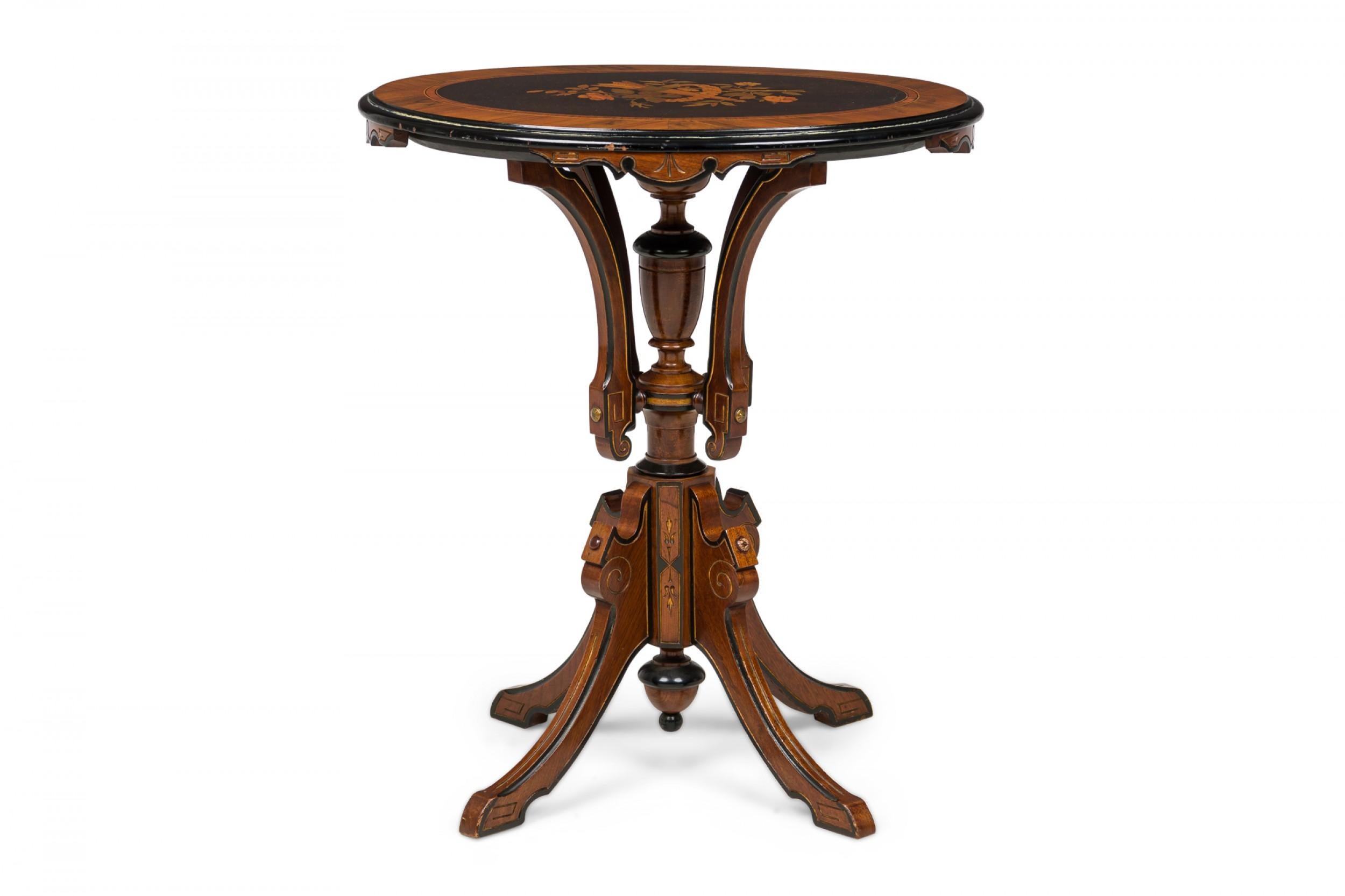 American Victorian wooden side table with gold leaf detailing, an oval top with an inlaid quiver design encircled by a floral spray, resting on a pedestal base with central turned urn design and four splayed carved legs.