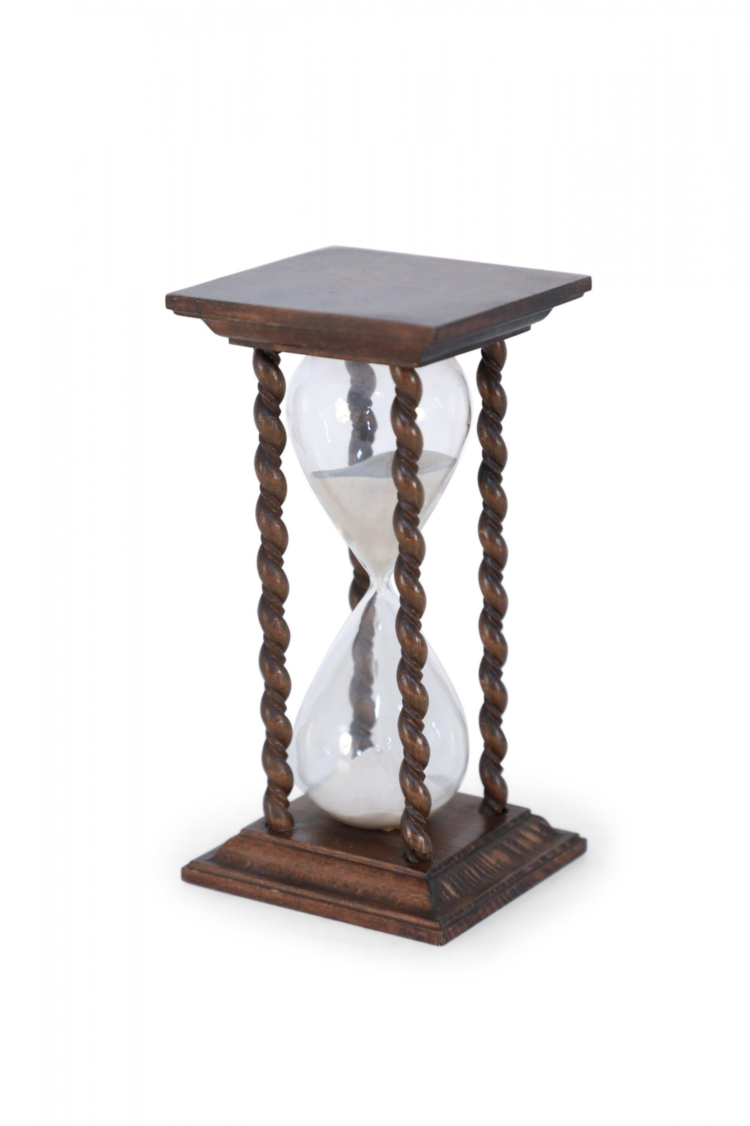 American Victorian (19th Century) wooden hourglass with turned spiral column supports and white sand.