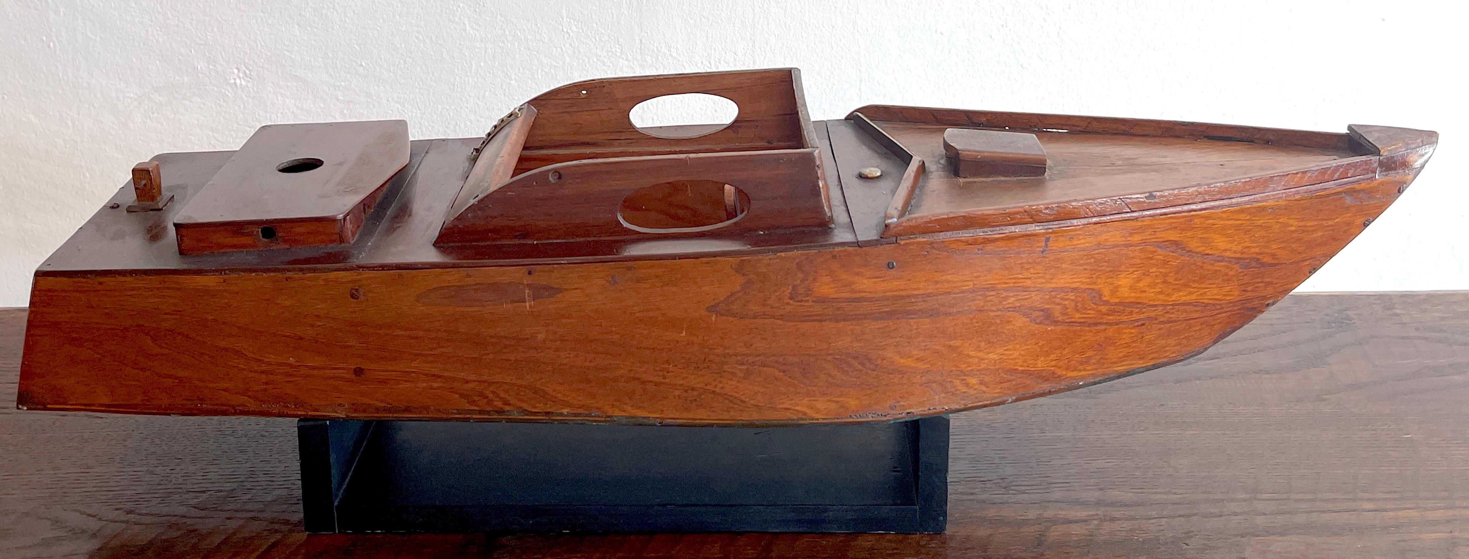 American vintage model of a Speedboat 'Ricky-O' Well crafted in hardwood with numerous details, The stern is inscribed 'Ricky-O' with a blue bottom. Complete with an ebonized display stand. Great color and patina. 
The boat stand measures 15.75