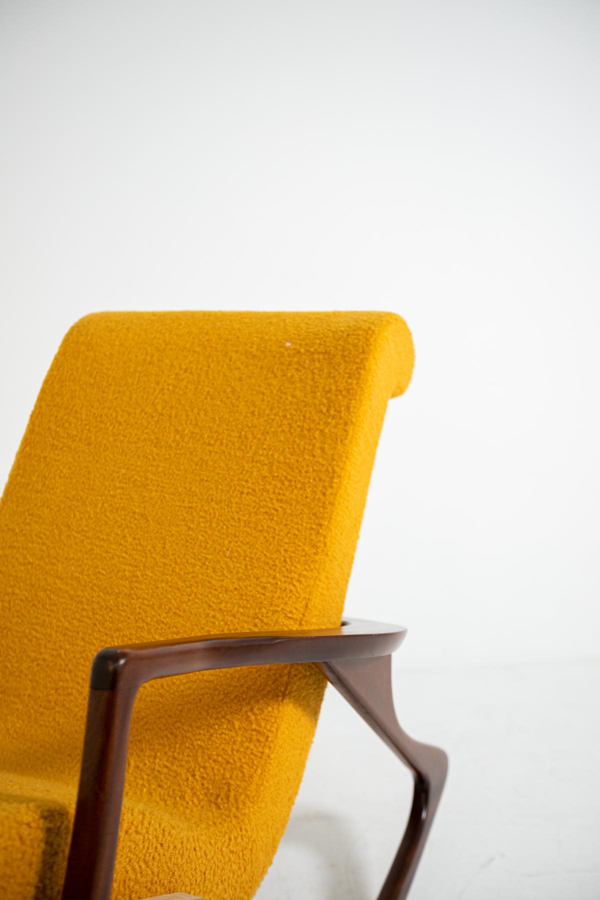 Elegant and sculptural midcentury American rocking chair. The armchair has been restored and refreshed in an elegant yellow bouclè. The seat and its back are one piece to give comfort to its guest. Its frame is made of walnut wood. Its fluid and