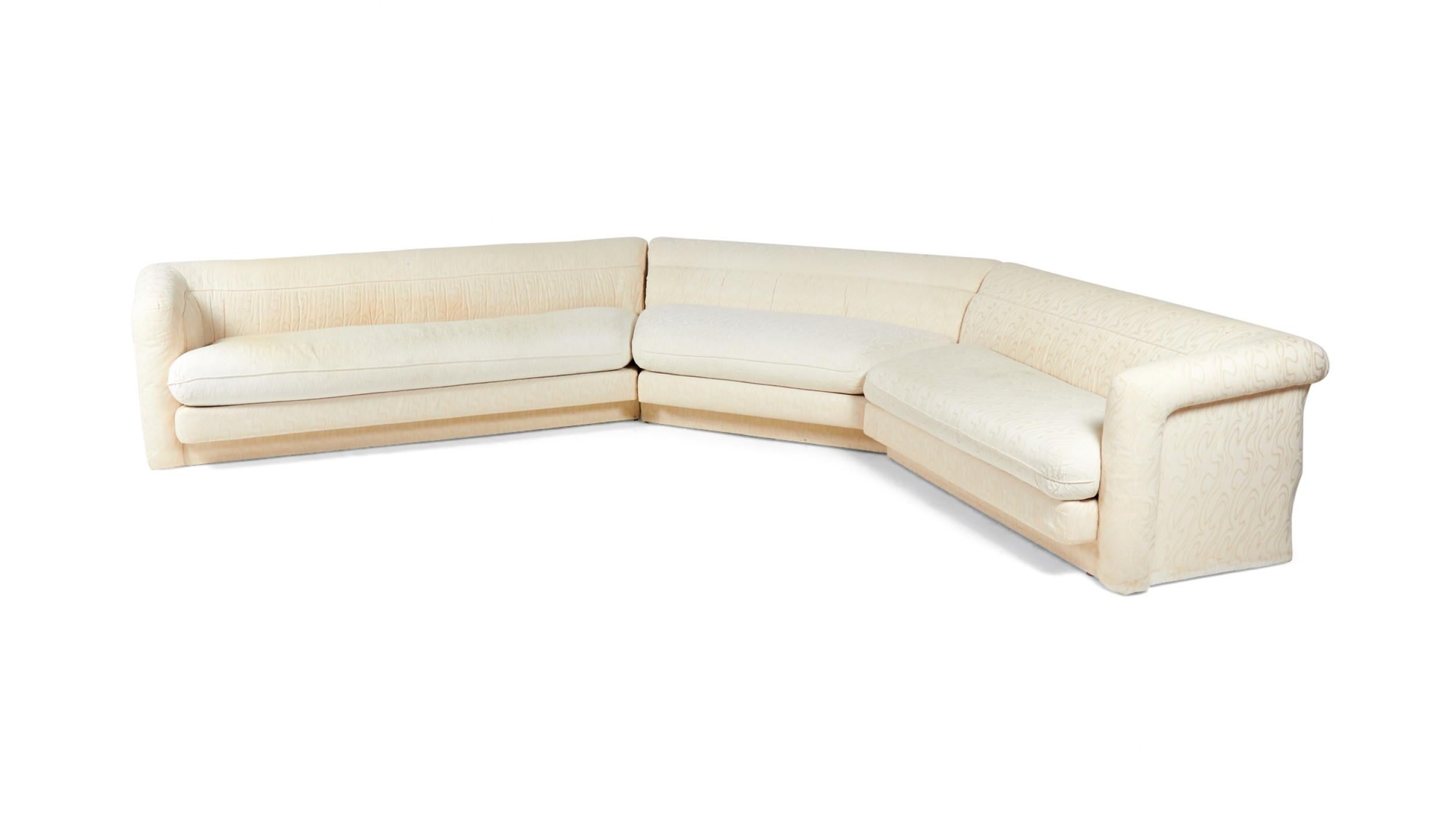 American Vintage (1980s) 3-piece sectional sofa with lightly swirl patterned white / cream upholstery, removable seat cushions, and arms on ends of two outer sections.
