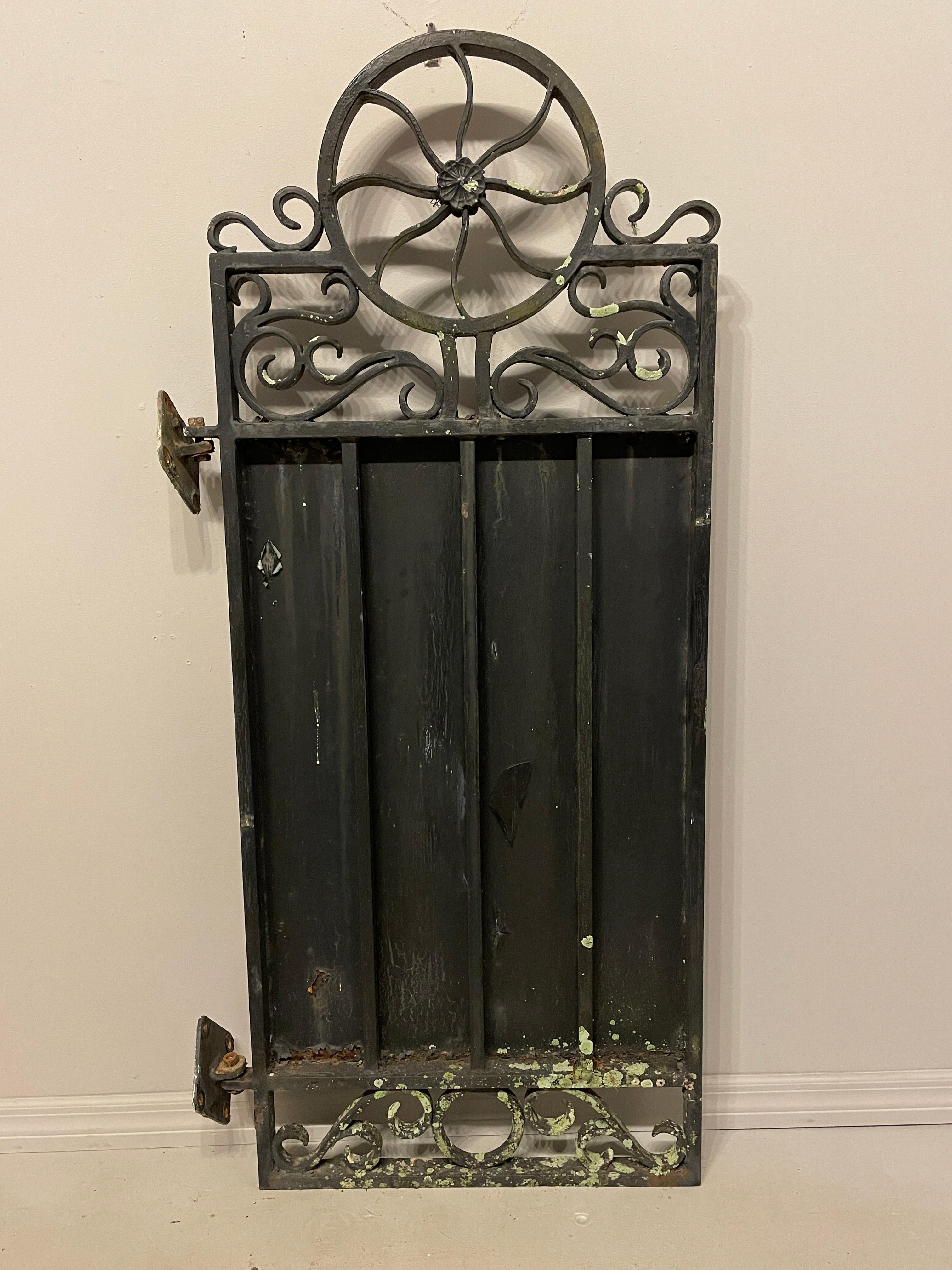 A heavy wrought iron gate with a scroll top. Door without hinge is 25