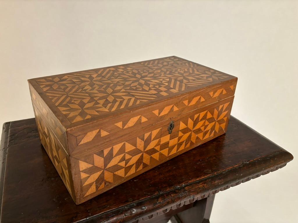 Wonderful 19th century American box with intricate and beautiful geometric and star pattern inlay, alternating between walnut and satin wood triangles, squares and bands.  Possibly sailor made on a long whaling voyage, a true piece of folk art.