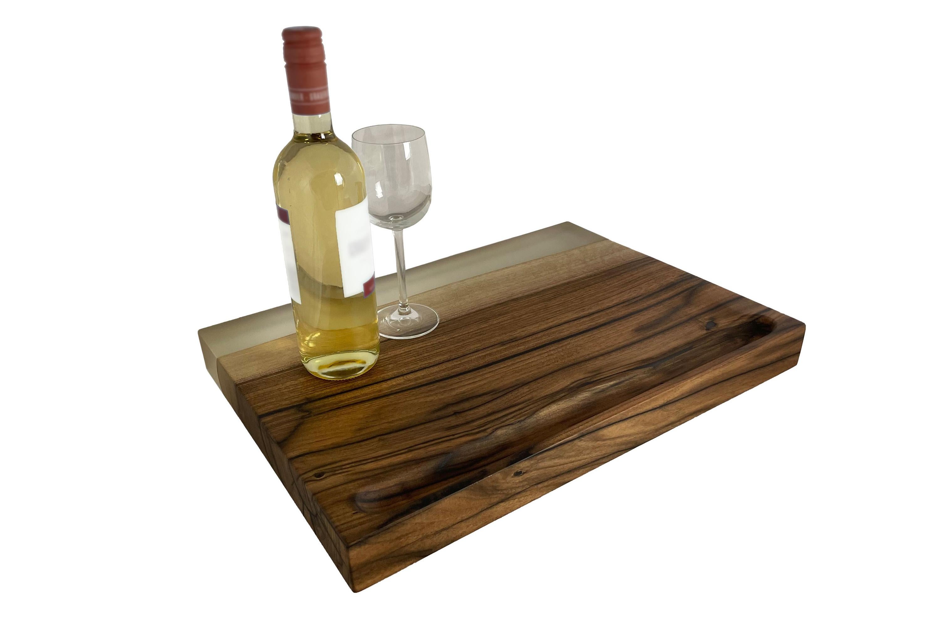 American walnut cutting board. The walnut was glued in multiple layers and cracks, knots, etc. were filled with high-quality epoxy. The surfaces are very finely ground and sealed with oil. A very large and gently tapering depression is milled into