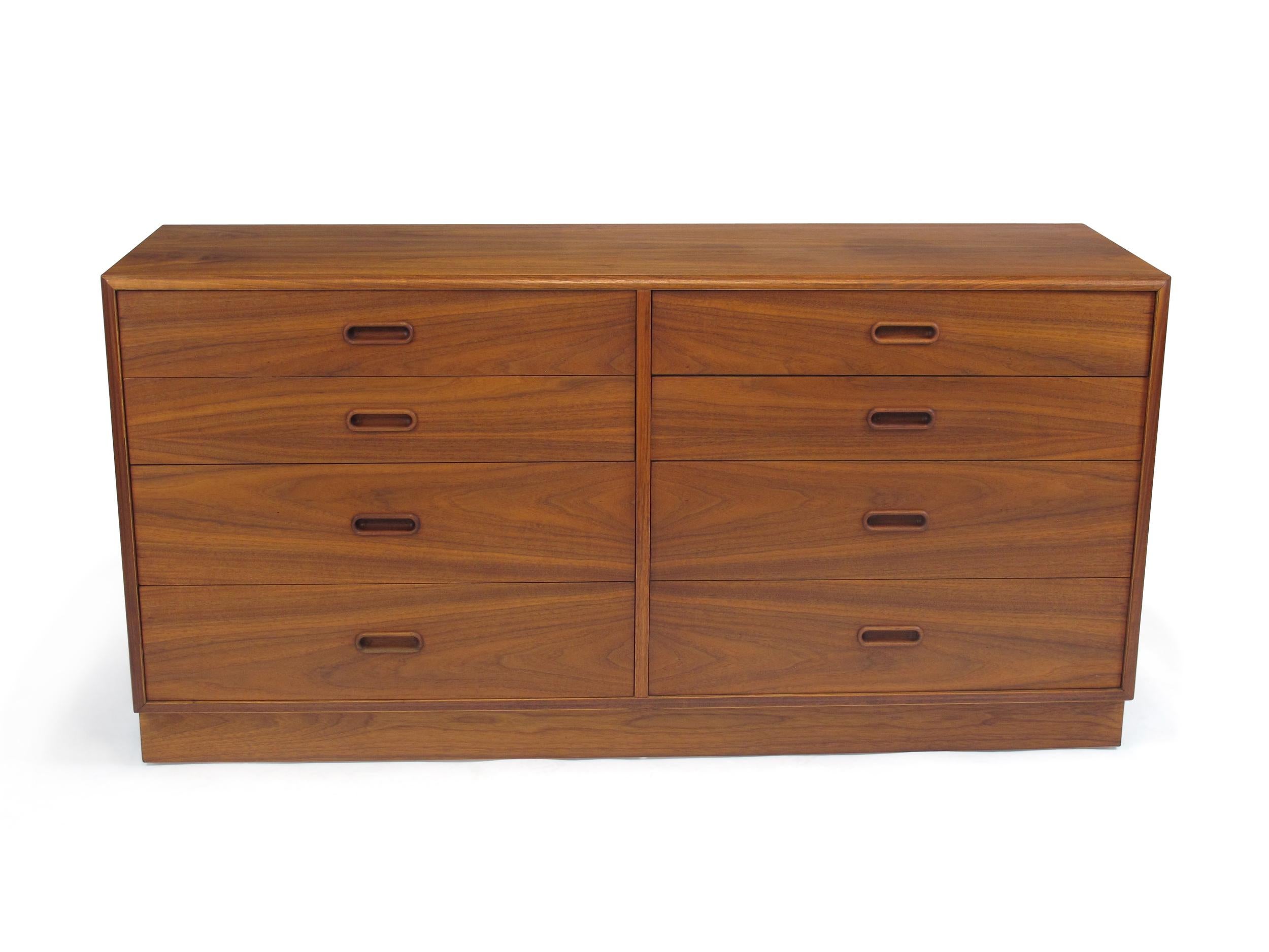 Midcentury walnut eight-drawer dresser crafted of walnut with carved drawer pulls on a plinth base.