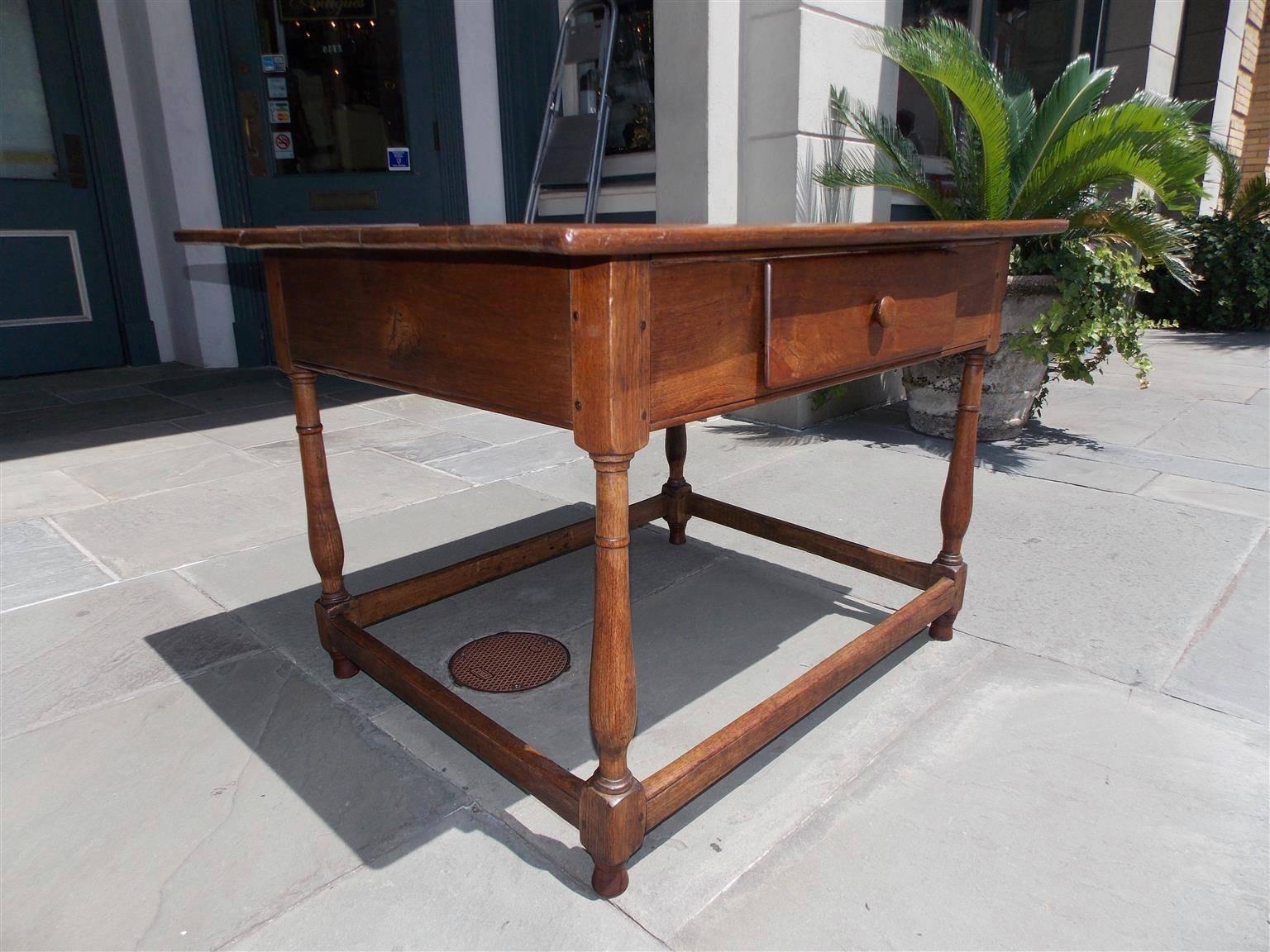 American walnut stretcher table with a carved molded edge top, single drawer with original wooden knob, and terminating on turned bulbous ring pegged legs with connecting stretchers, Early 18th century. Northeastern, North Carolina. Secondary wood